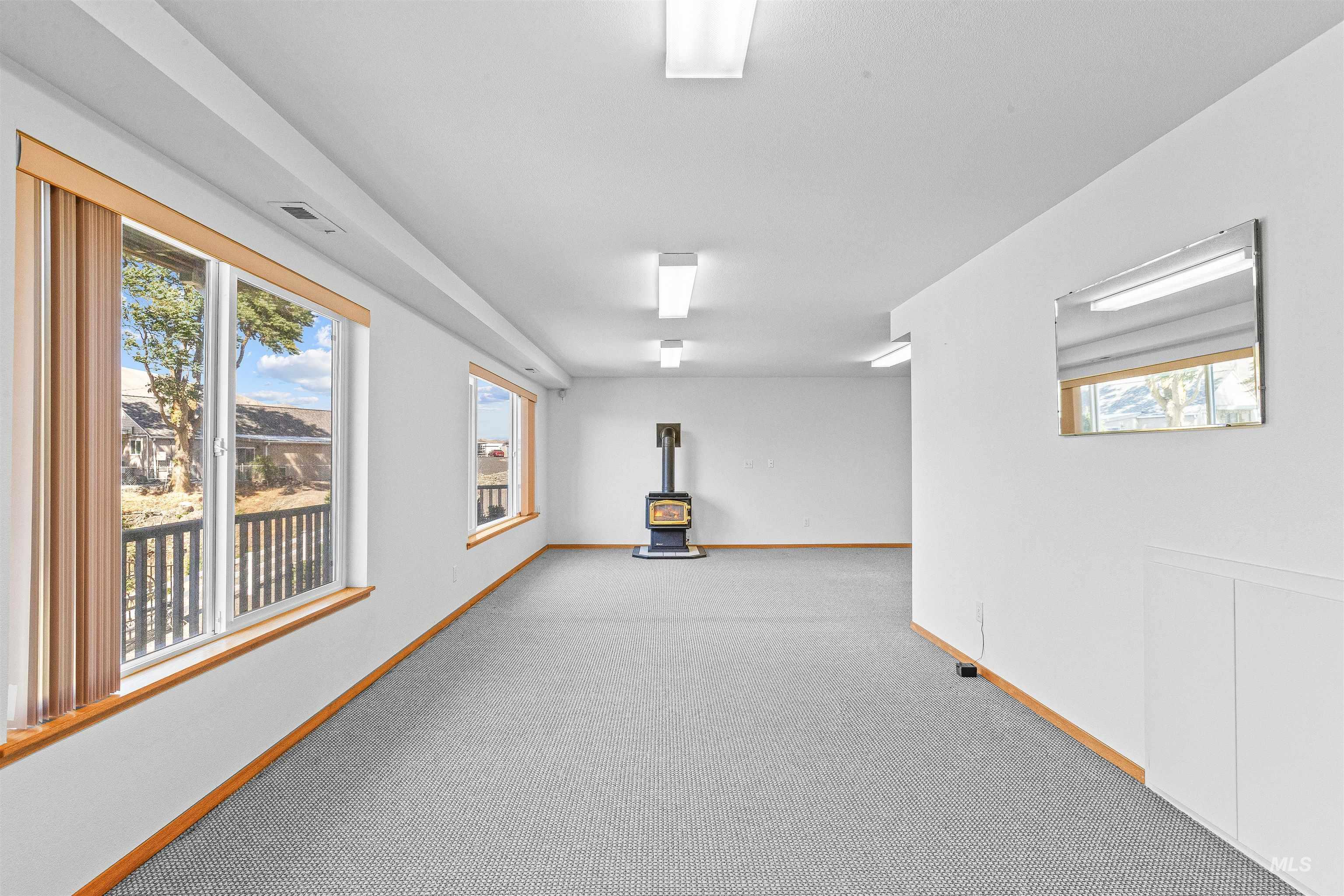 Empty room featuring a wood stove and carpet floors