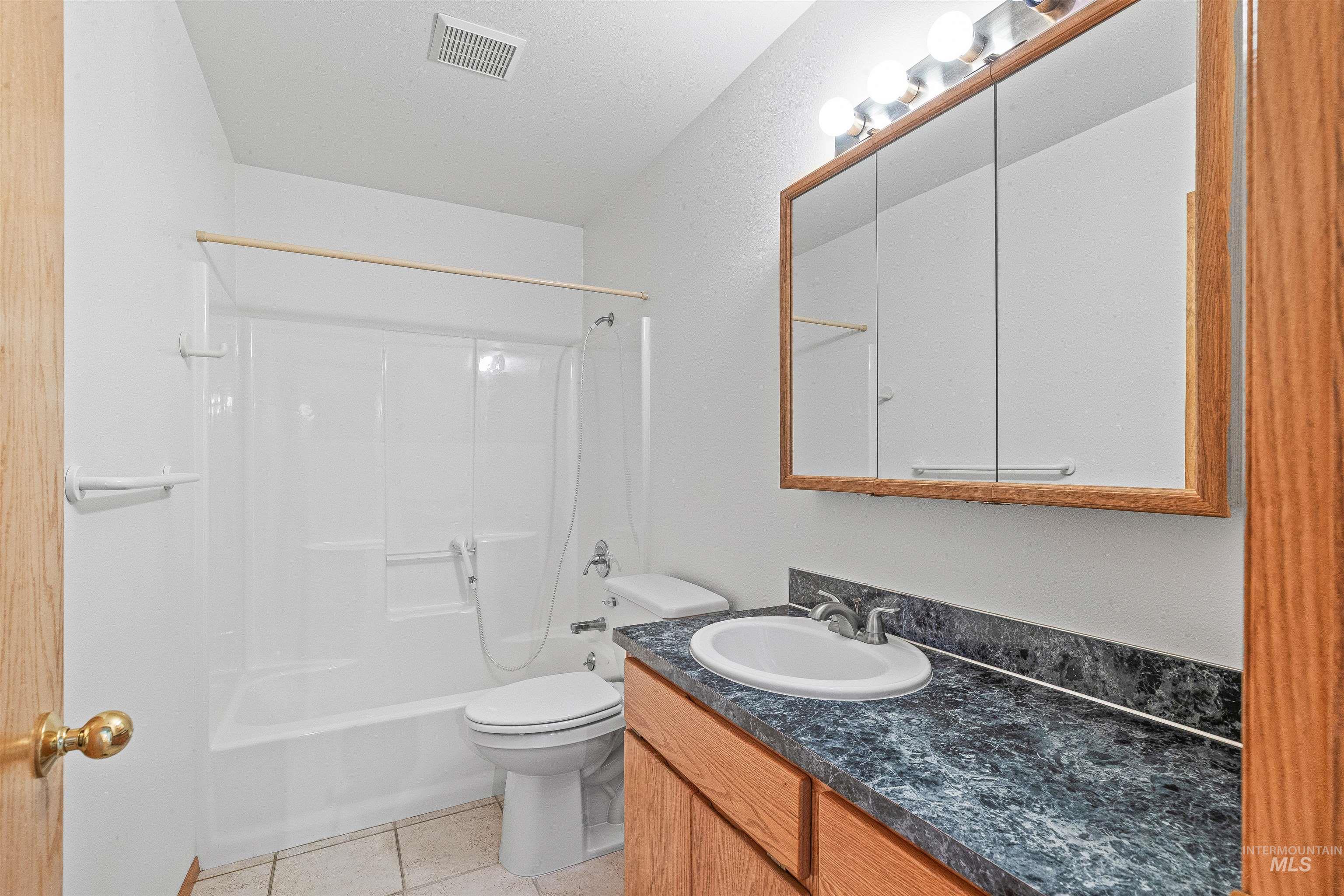 Full bath featuring vanity,  shower combination, and tile patterned flooring
