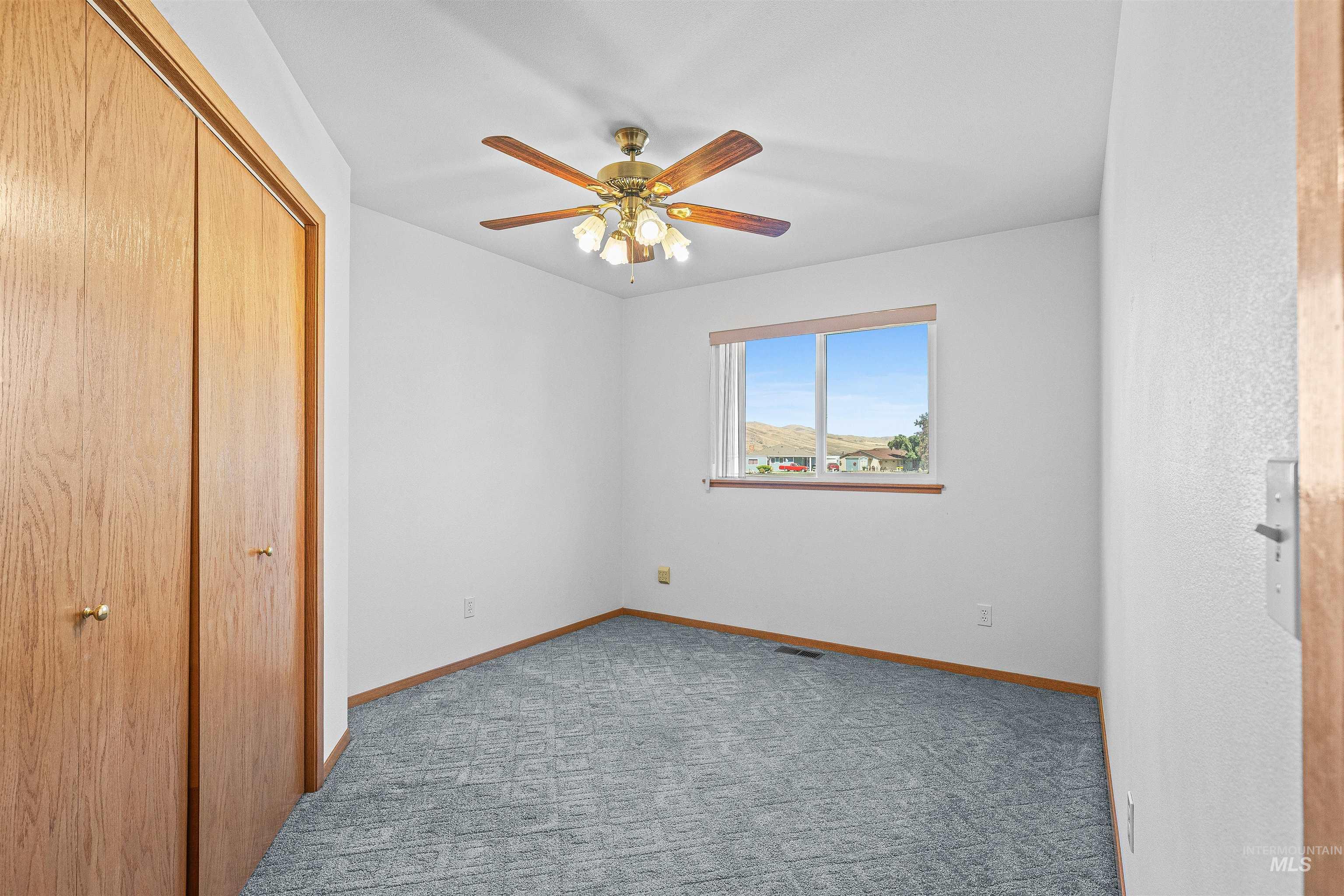 Unfurnished bedroom with a closet, carpet flooring, and a ceiling fan