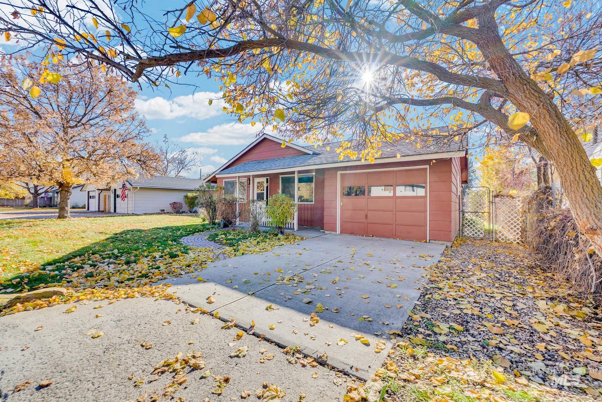 View of front facade with an attached garage, driveway, and a gate