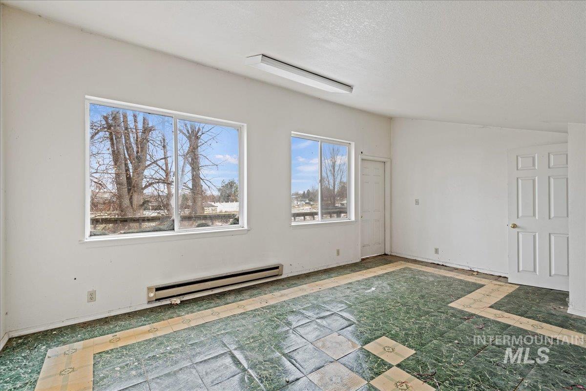 Empty room featuring baseboard heating and a textured ceiling