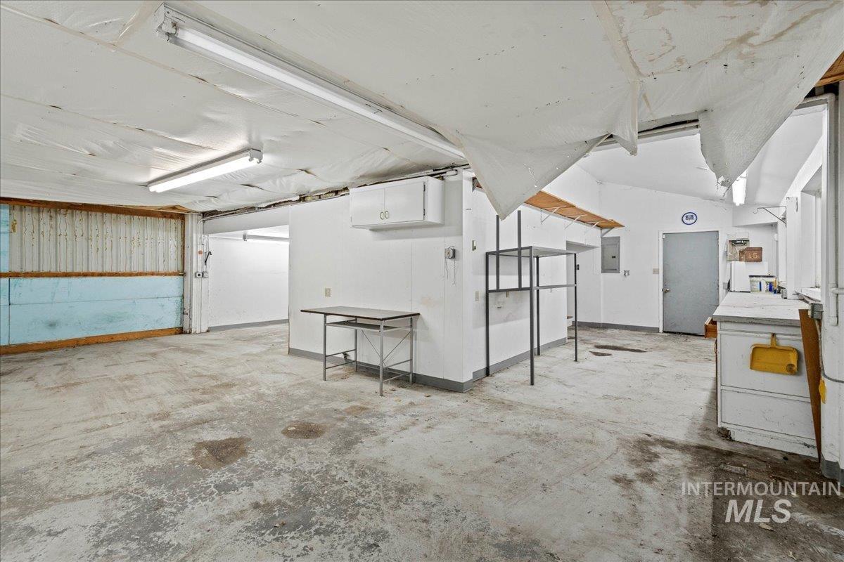 Miscellaneous room with unfinished concrete floors and electric panel
