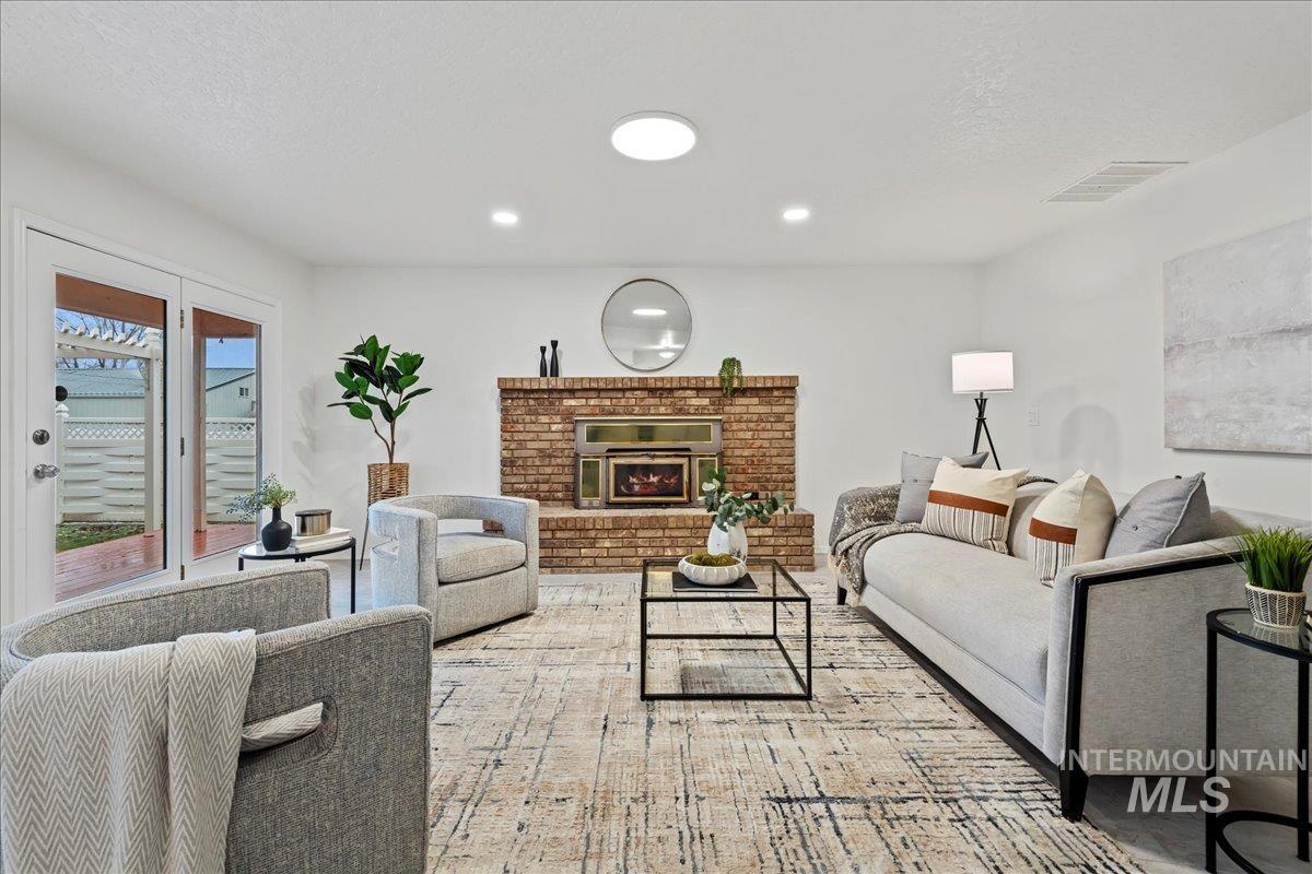 Living room with a fireplace, recessed lighting, and a textured ceiling