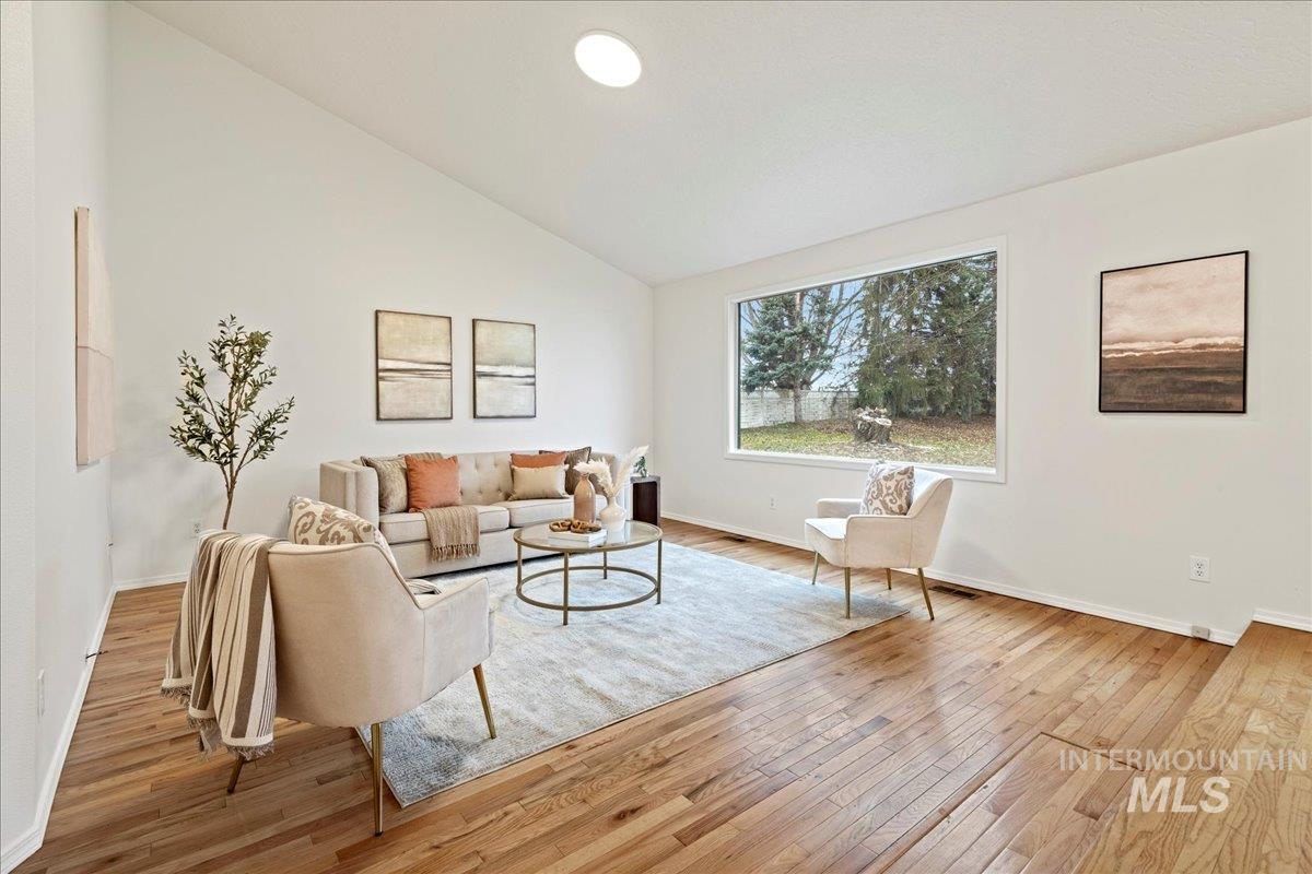 Living area with light wood-style flooring and high vaulted ceiling