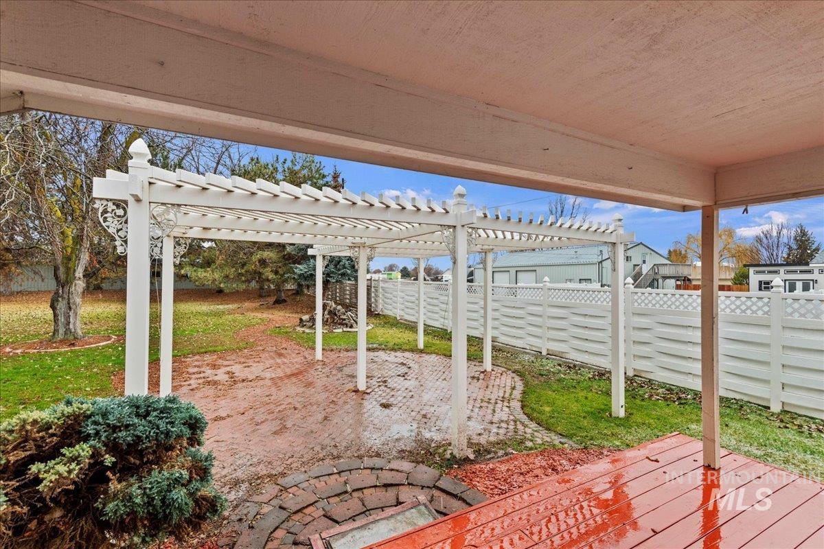 Fenced backyard with a pergola and a patio