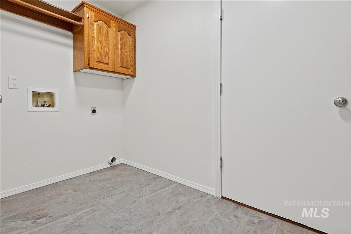 Washroom featuring hookup for a washing machine, electric dryer hookup, and cabinet space