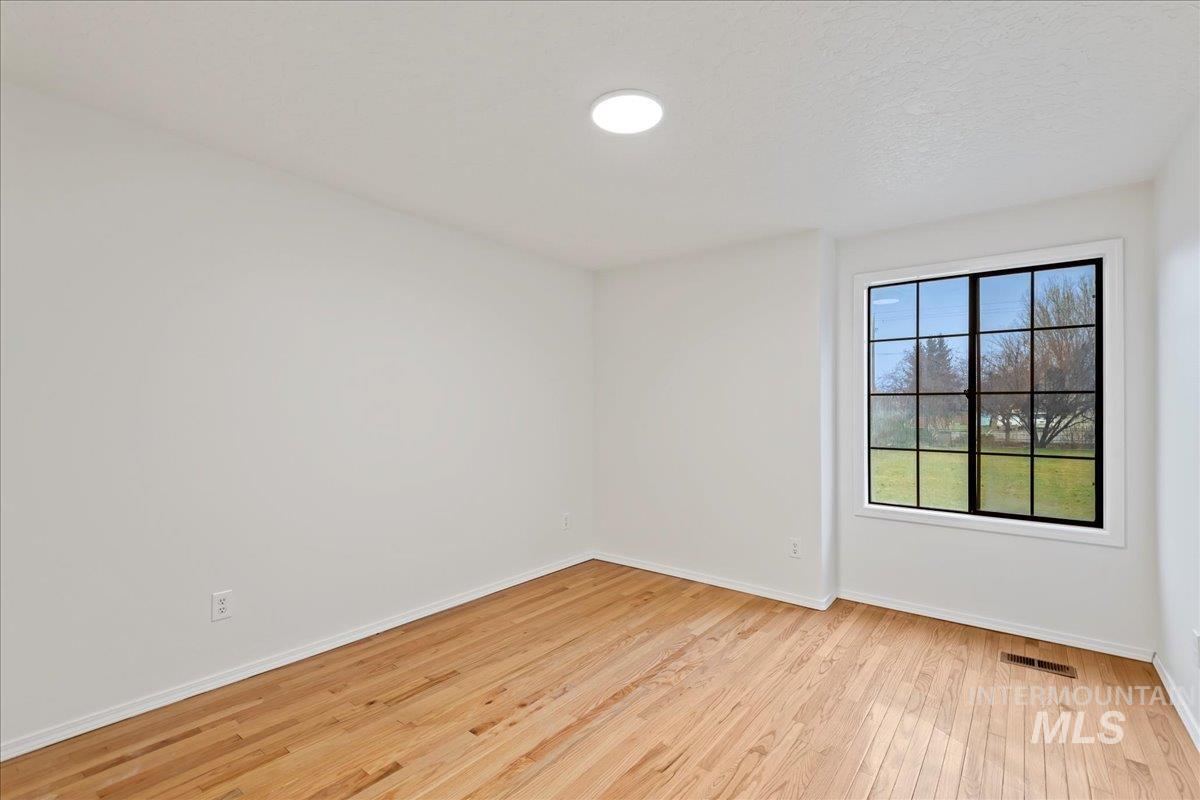 Empty room with light wood-style floors and a textured ceiling