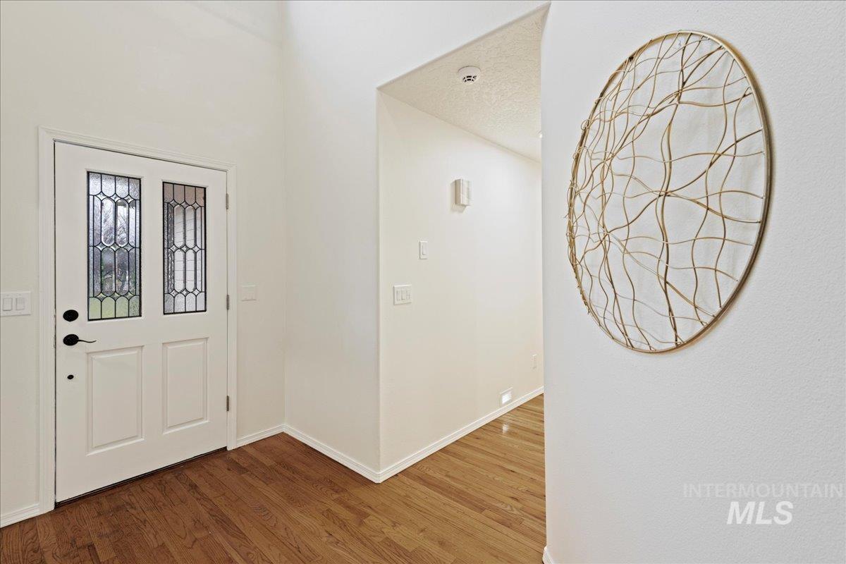 Foyer entrance with wood finished floors and baseboards
