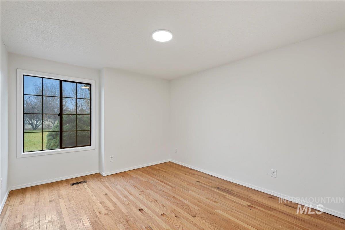 Spare room with light wood-style flooring and a textured ceiling