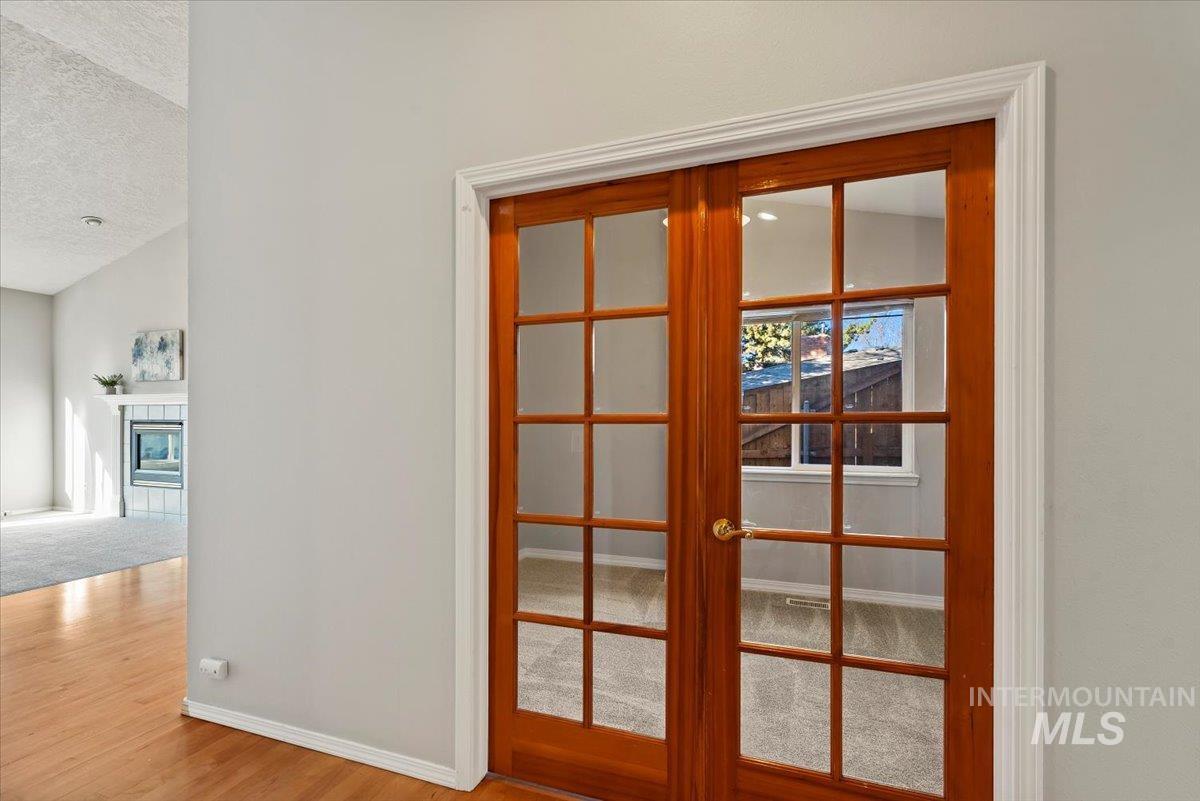 Detailed view of a tile fireplace, carpet flooring, and wood finished floors
