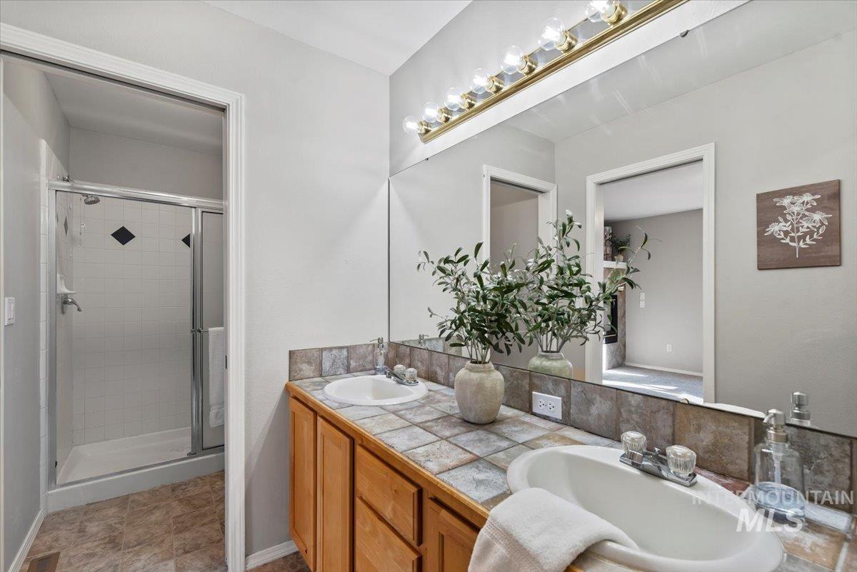 Bathroom with double vanity and a stall shower