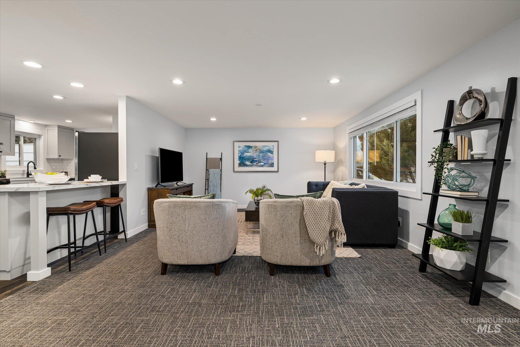 Living room featuring dark carpet, plenty of natural light, and recessed lighting