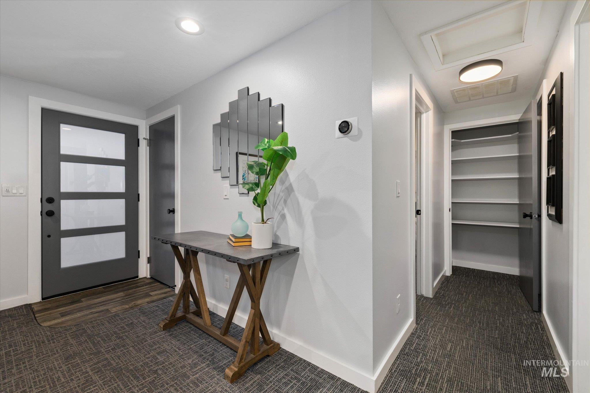 Hall with dark colored carpet and baseboards