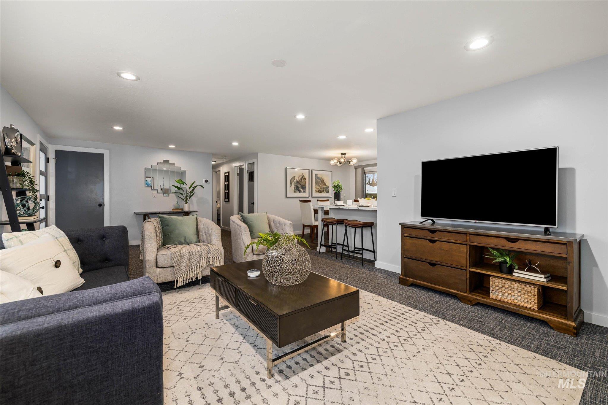 Carpeted living area with baseboards and hanging lights