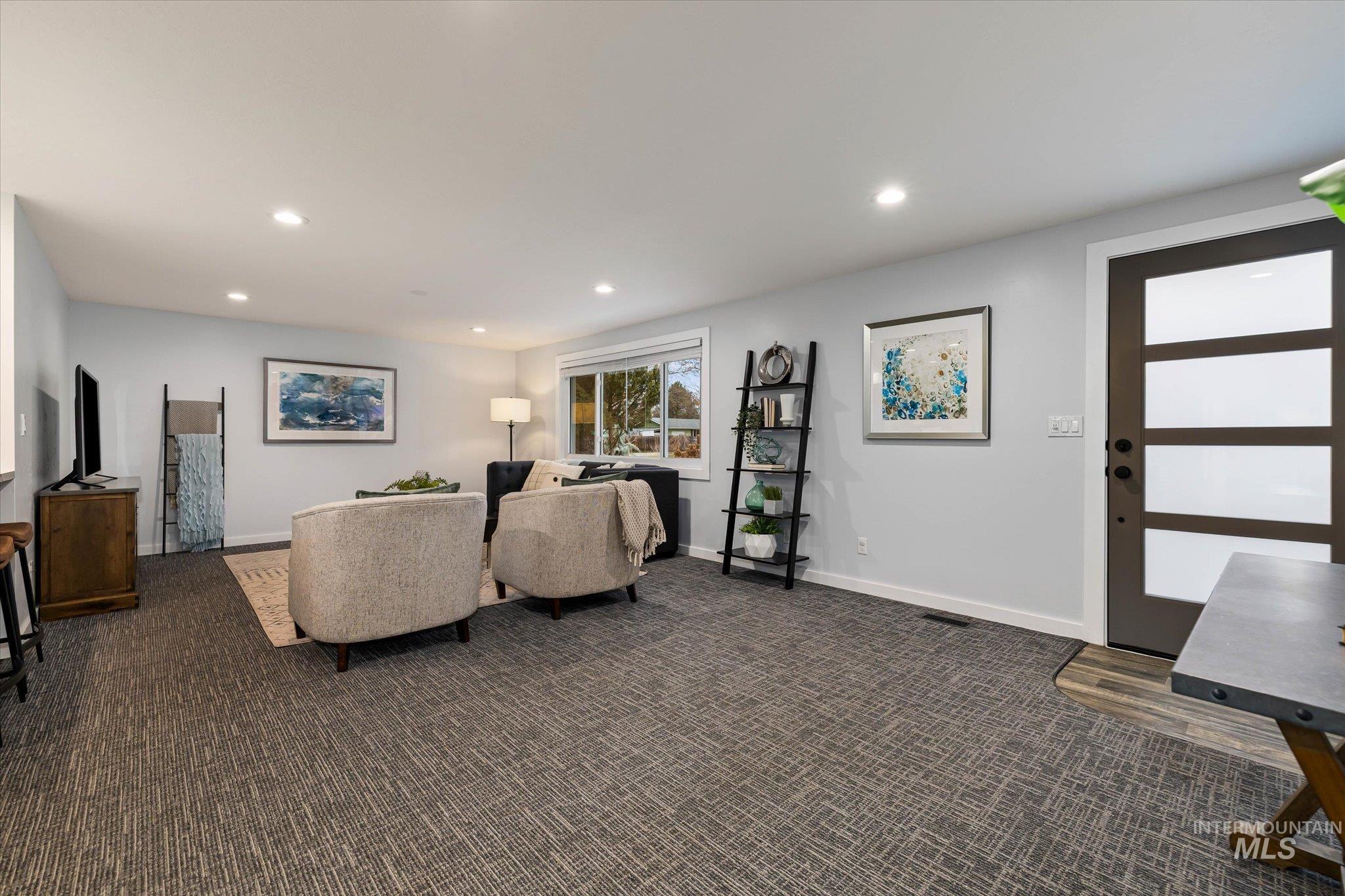 Living area featuring dark carpet and recessed lighting