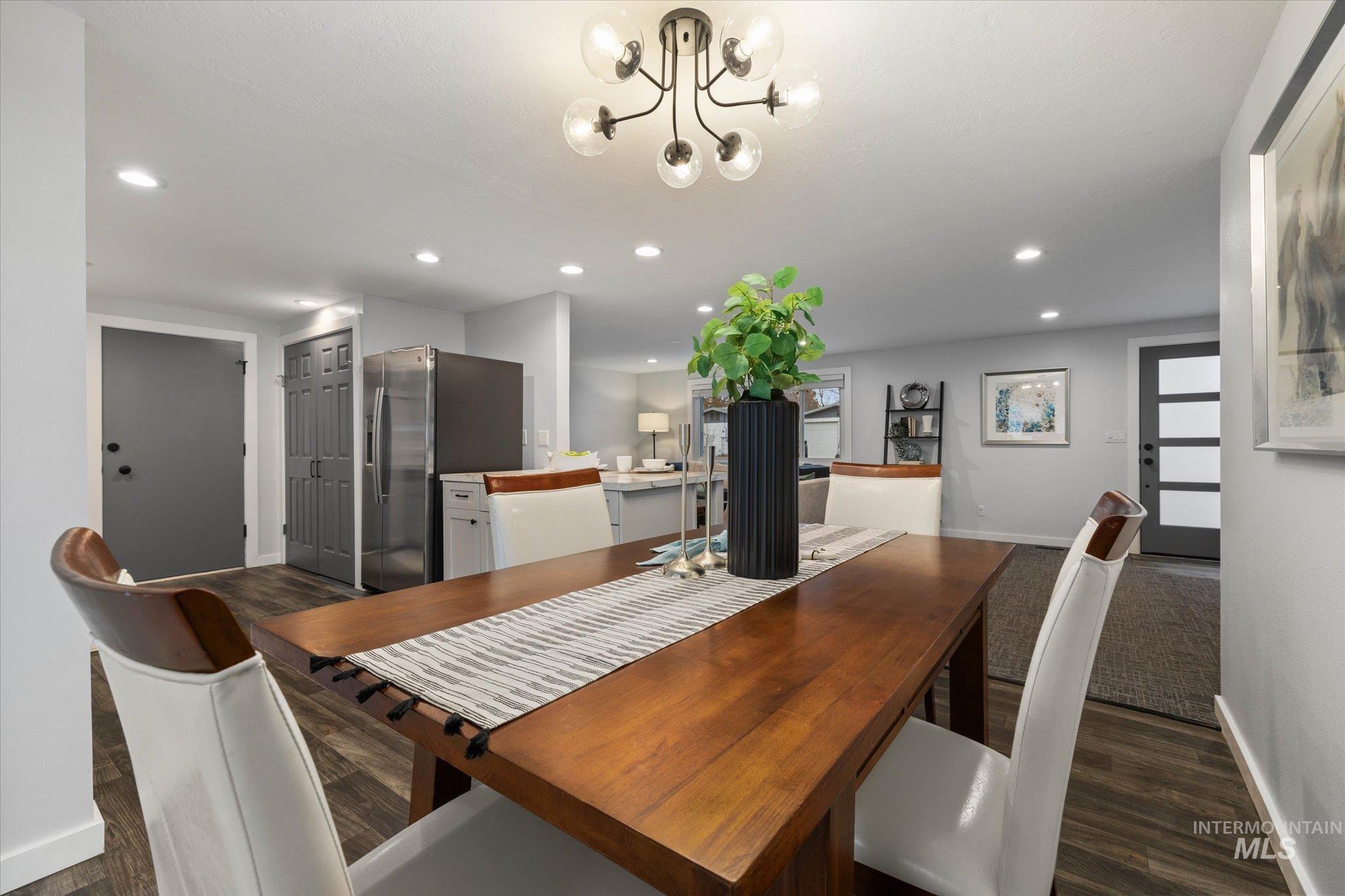 Dining area featuring dark wood-style floors and suspended lighting