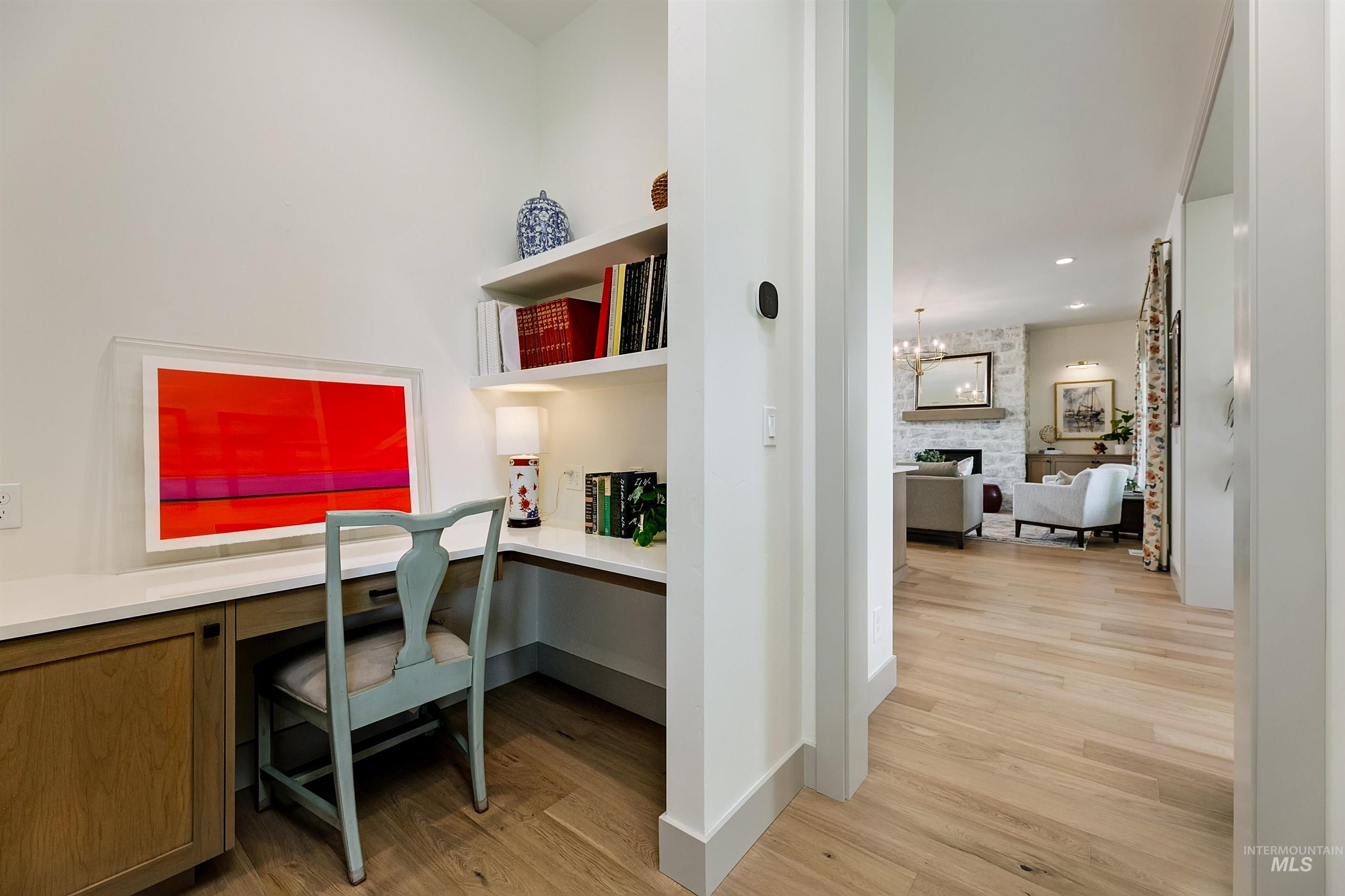 Built-in desk nook featuring an integrated wood-finish cabinet, white countertop, and open shelving