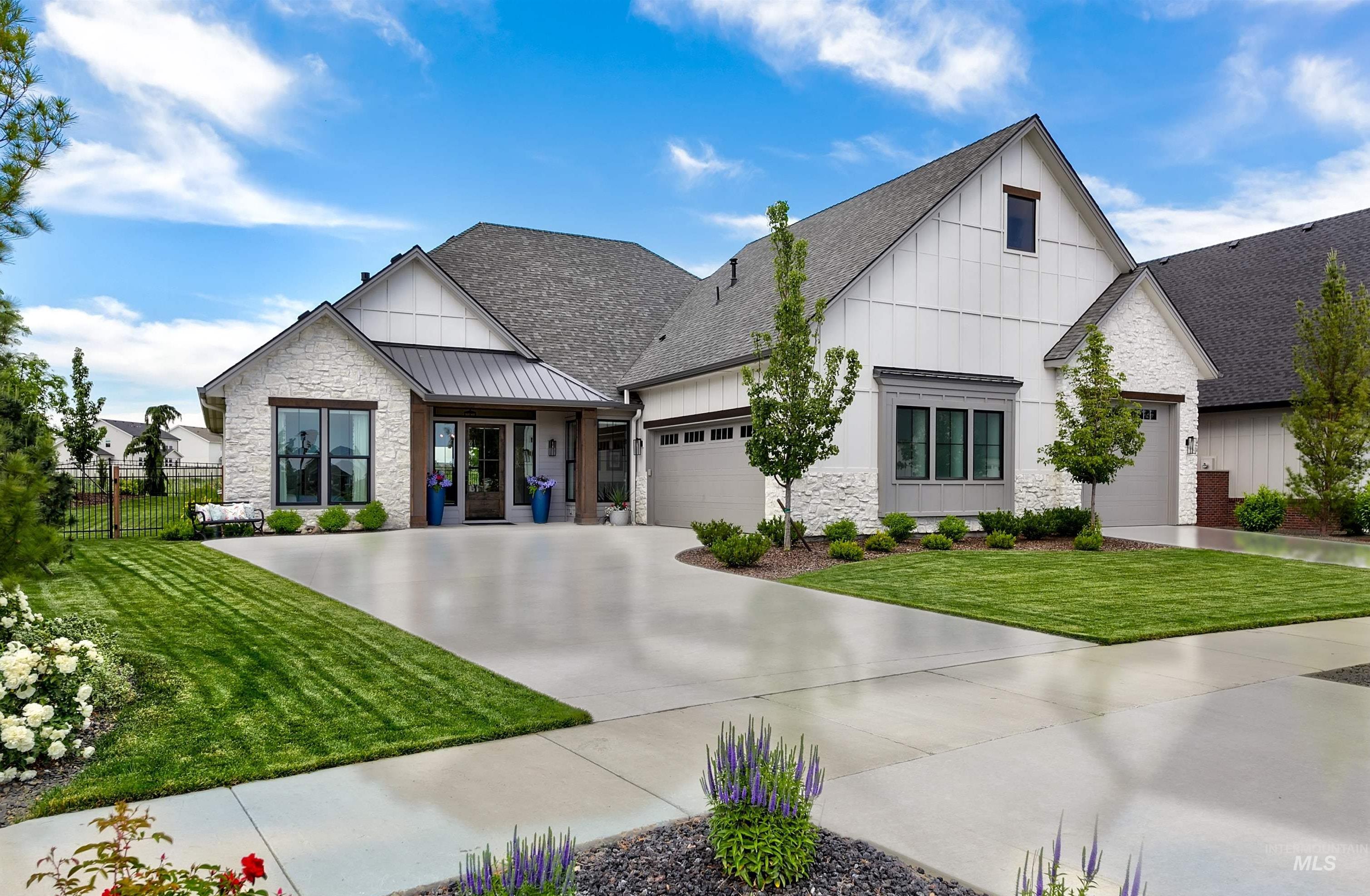 Contemporary residence with a blend of white board-and-batten siding and light-colored stone veneer