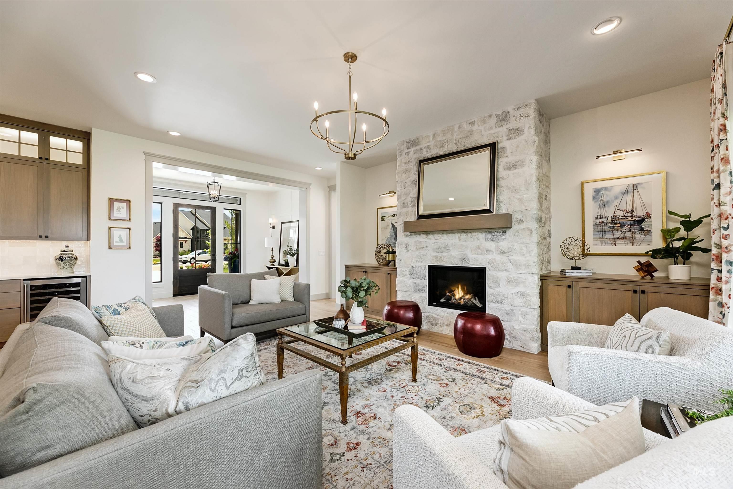 Spacious living area featuring a floor-to-ceiling stone fireplace with a wood mantle, built-in cabinetry, and recessed lighting