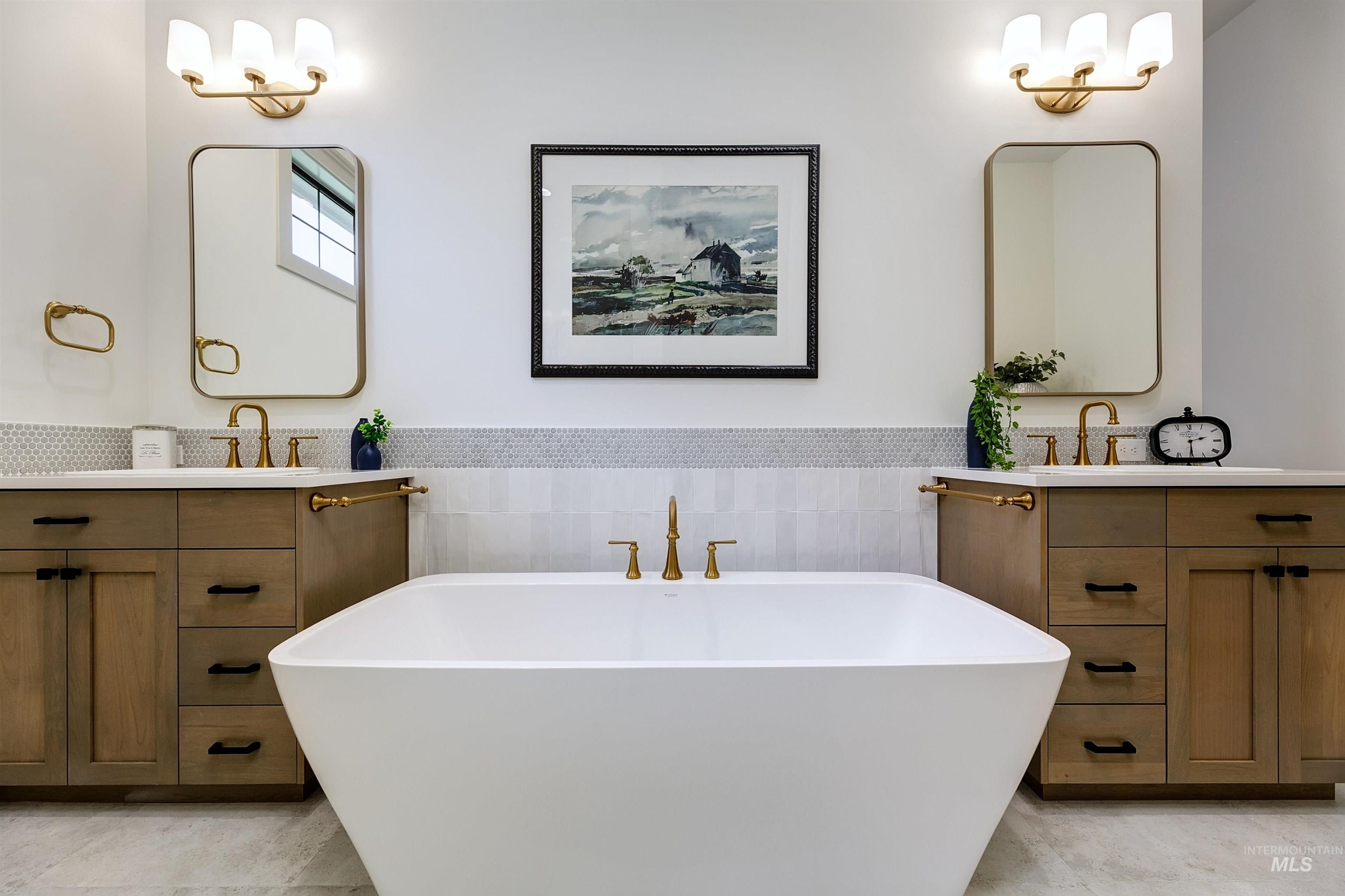 Freestanding soaking tub with a floor-mounted gold-finish faucet