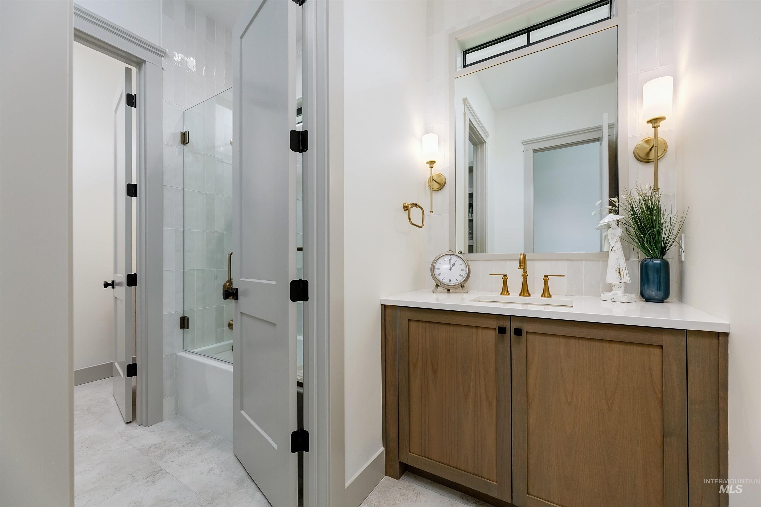Bathroom vanity with wood-finish cabinetry and a white countertop
