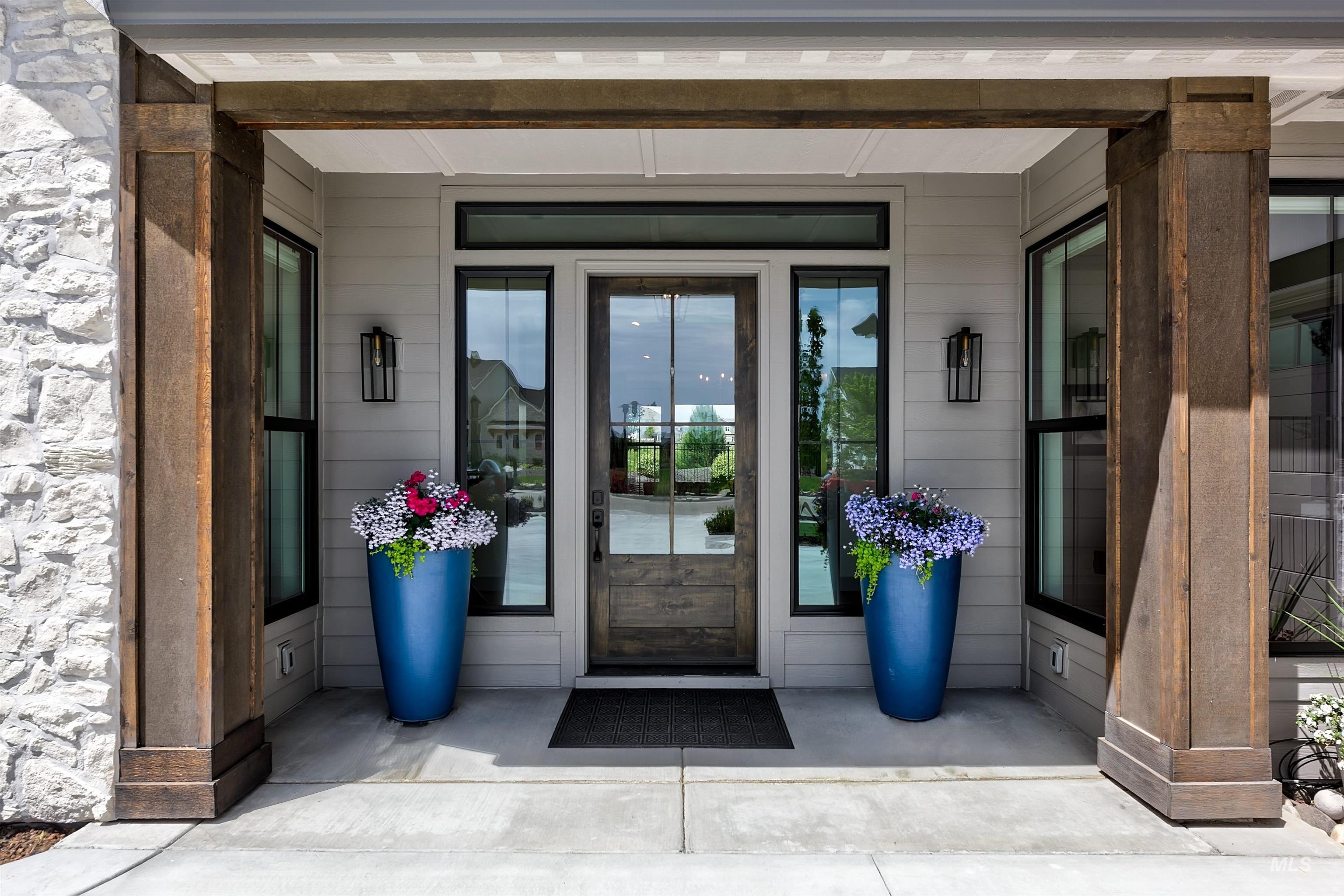 Inviting covered entryway featuring a paneled wood-finish door with sidelights and transom window