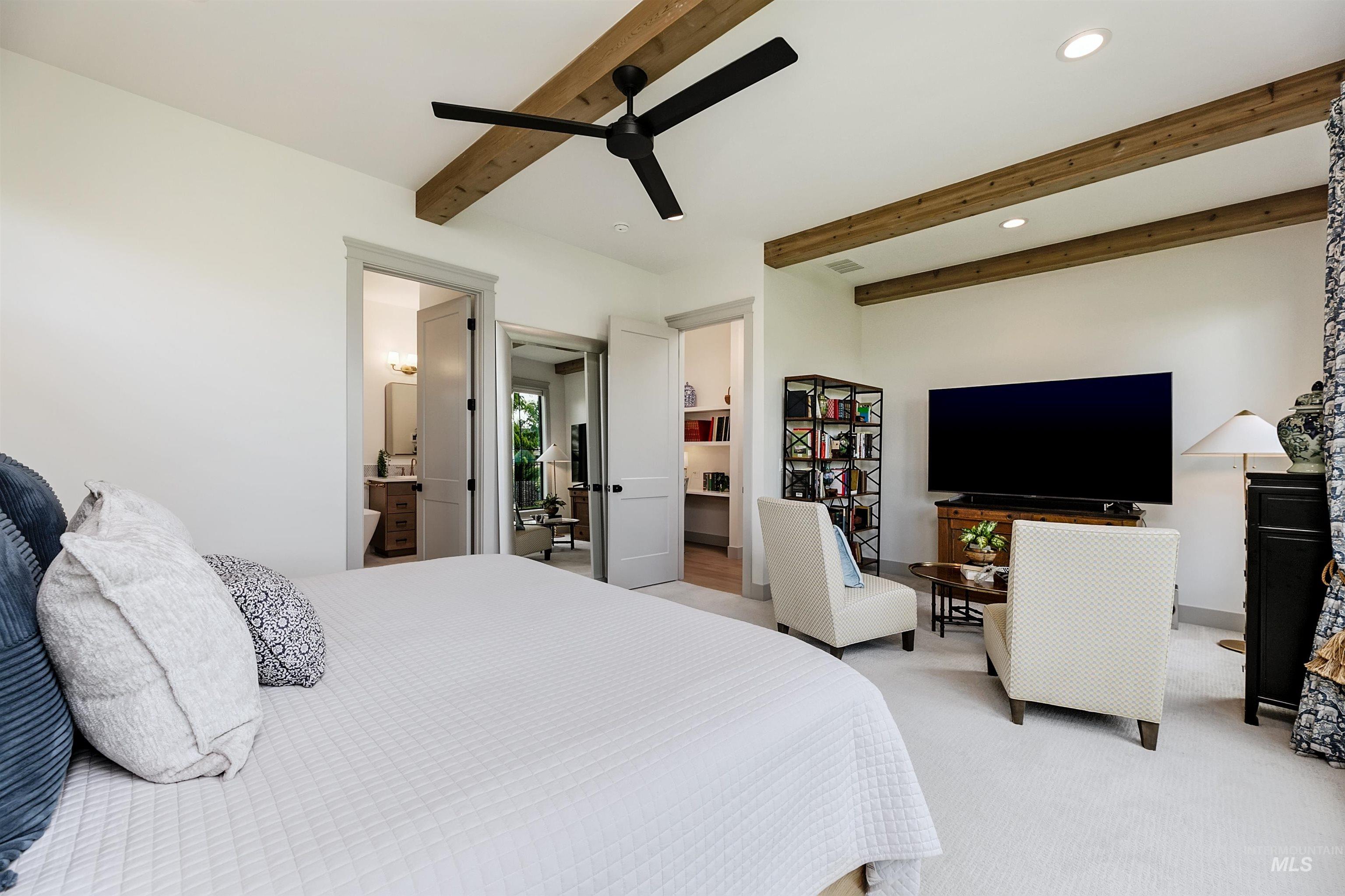 Spacious room featuring exposed wood beams, a contemporary ceiling fan, and recessed lighting