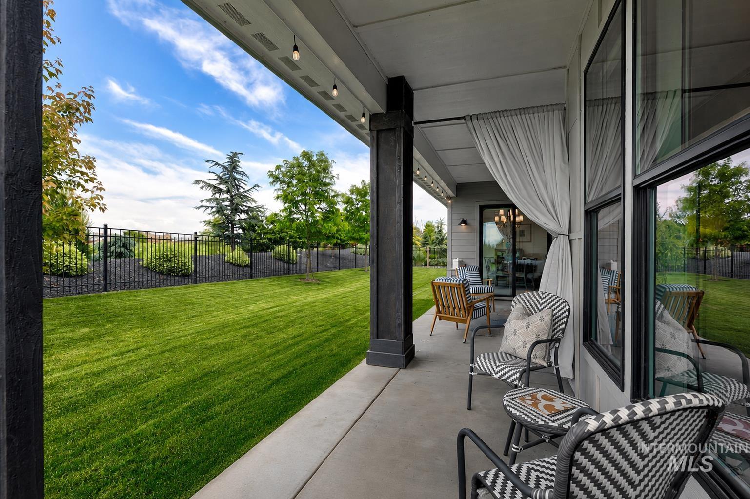 Covered patio featuring concrete flooring, black support columns, recessed lighting, and large windows with black framing