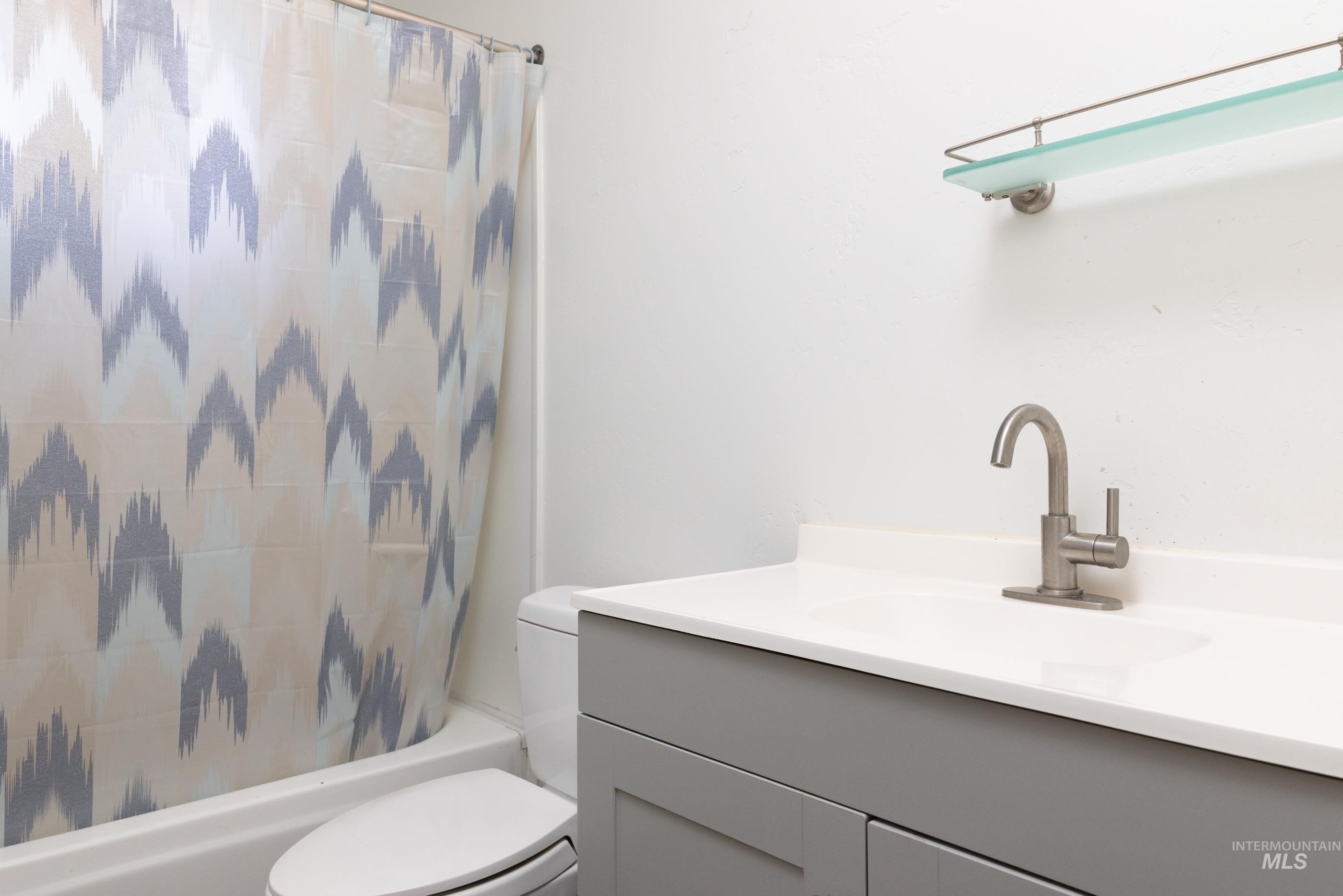 Bathroom featuring shower / tub combo with curtain and vanity