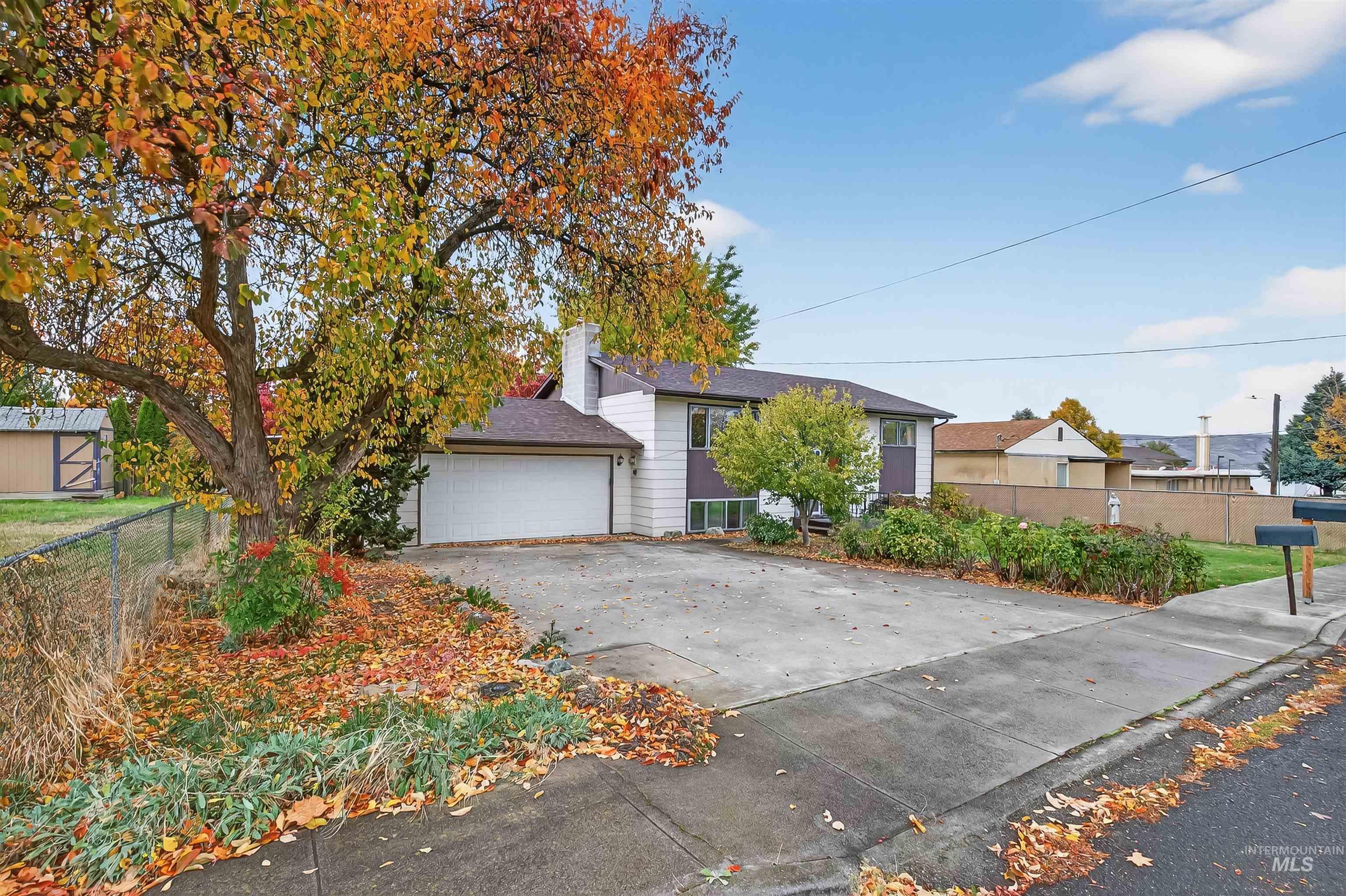 View of front facade with driveway and a chimney