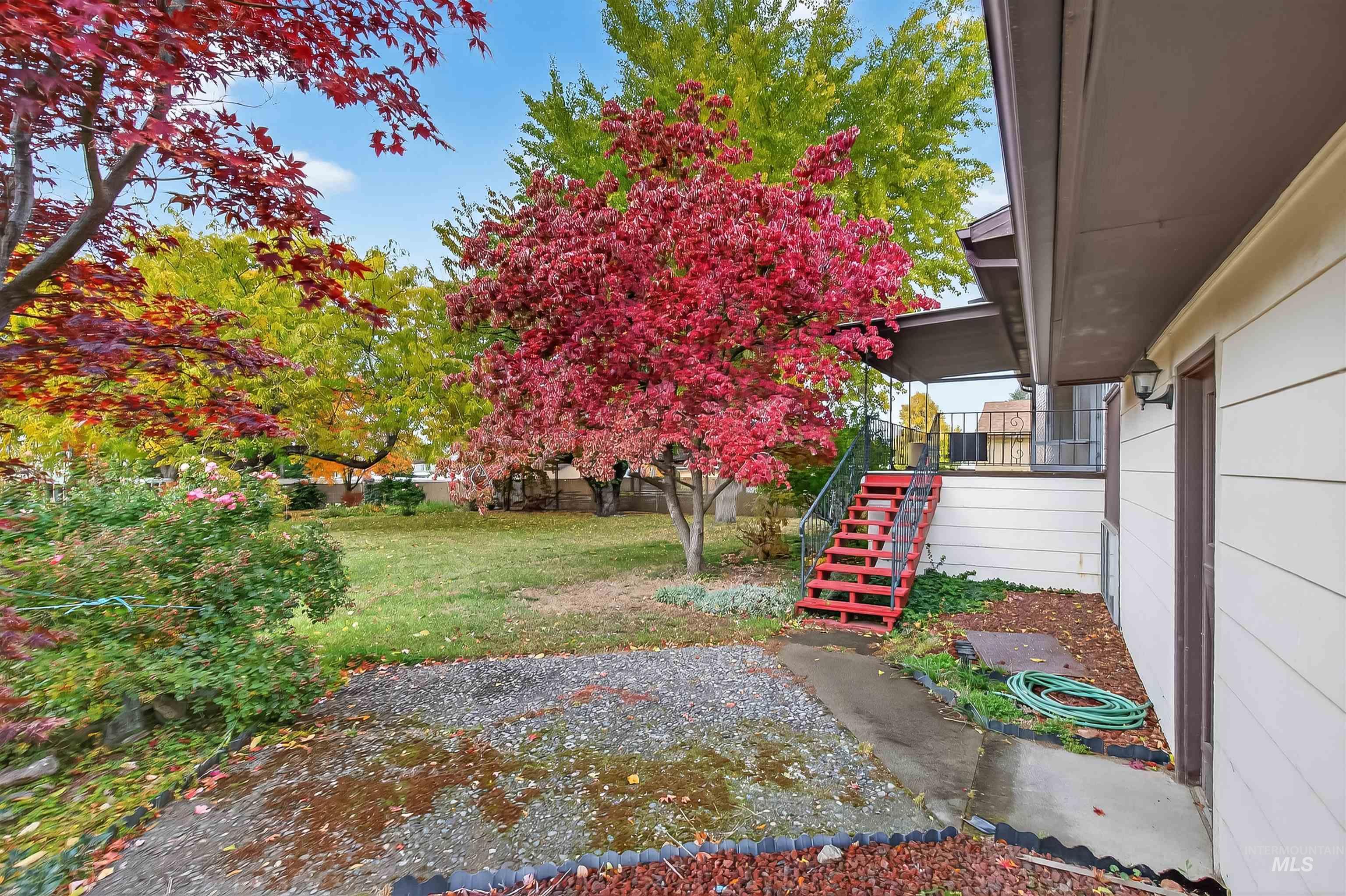 View of yard featuring stairs and covered porch