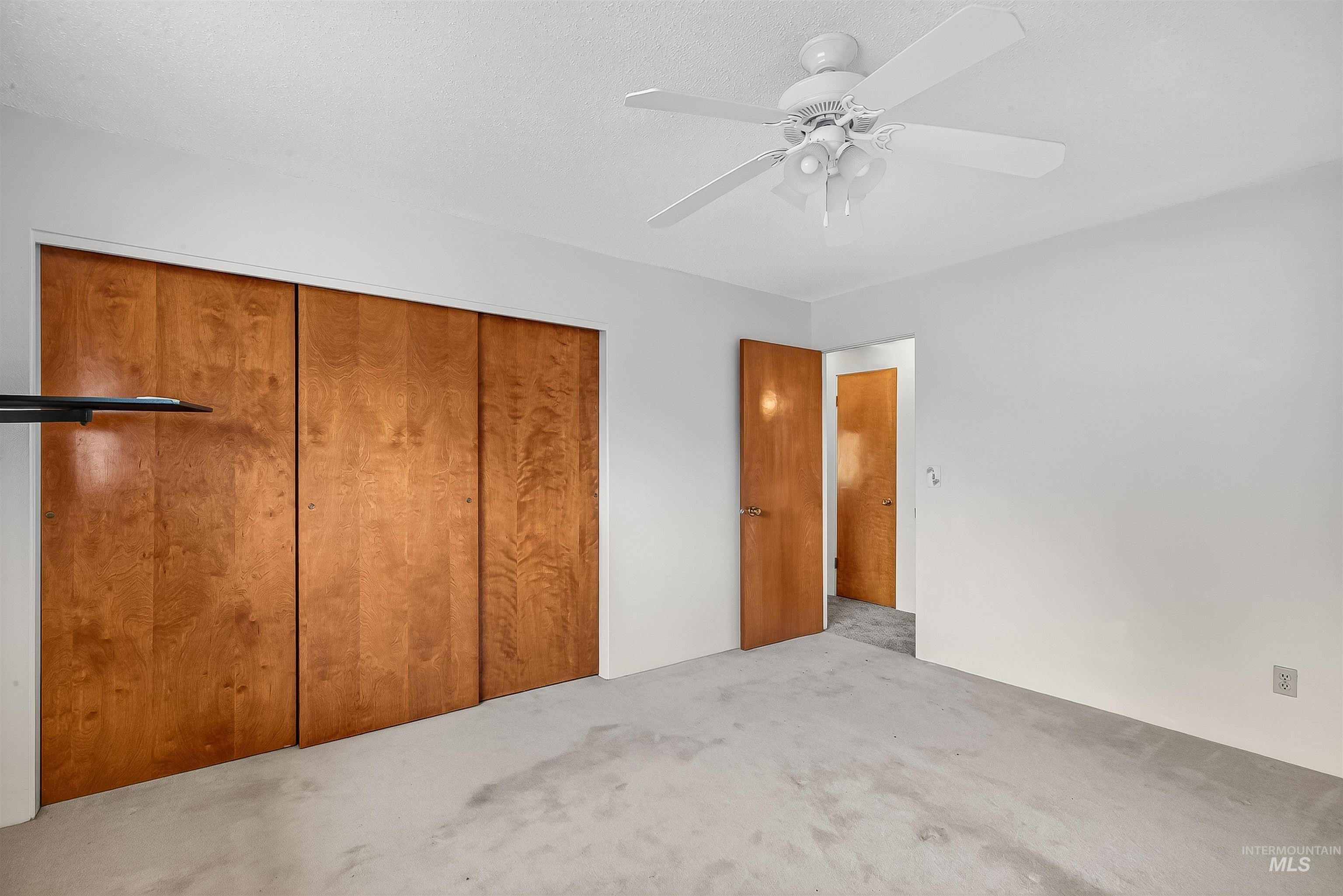 Unfurnished bedroom with a closet, ceiling fan, and carpet