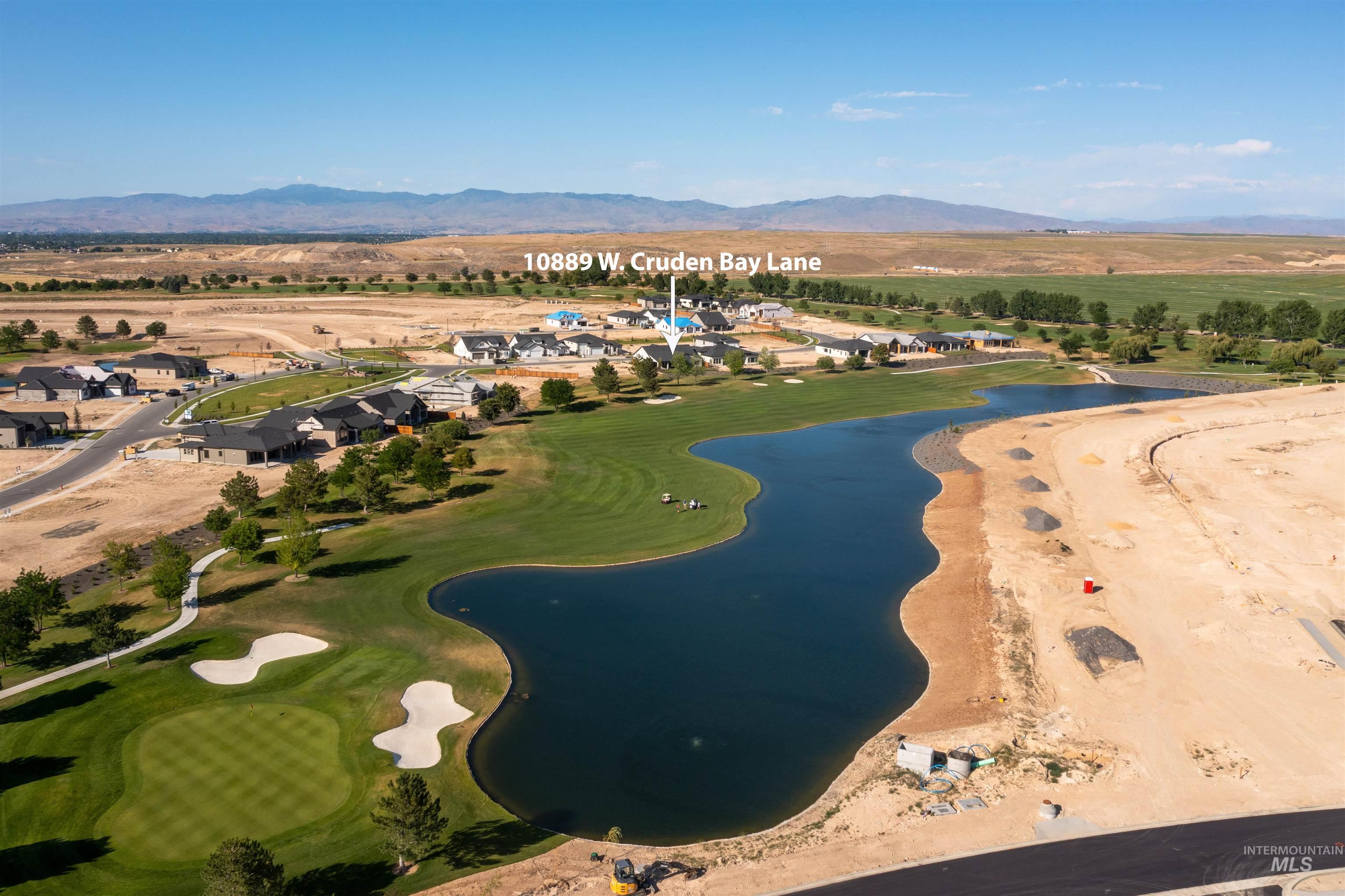 Aerial view of property and surrounding area with a water and mountain view and nearby suburban area
