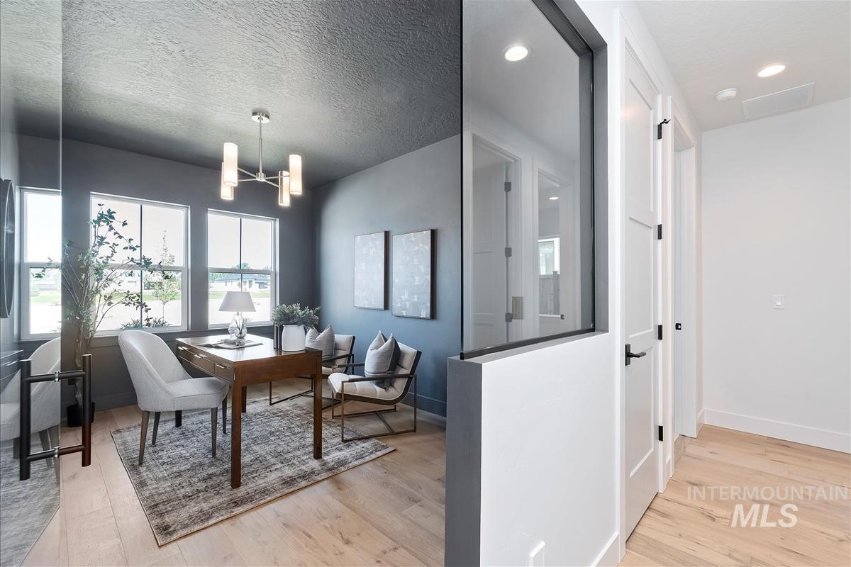 Dining room featuring wood finished floors, a chandelier, a desk, and recessed lighting