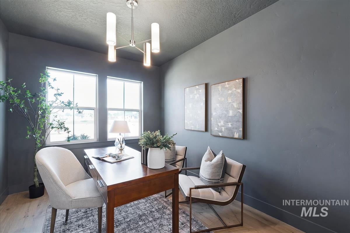 Home office featuring wood finished floors, healthy amount of natural light, and a textured ceiling