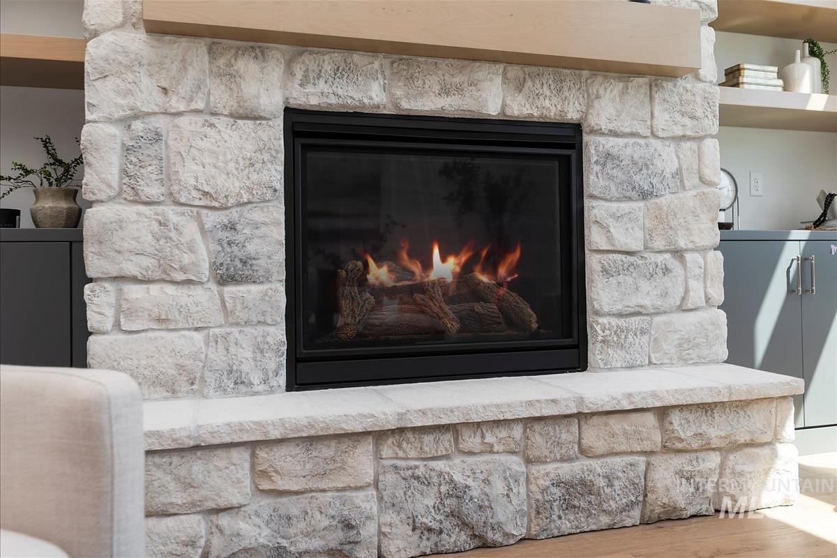 Detailed view of a glass covered fireplace and wood finished floors