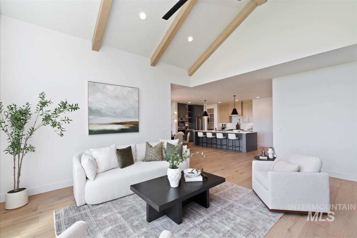 Living area featuring light wood-style floors, beam ceiling, recessed lighting, ceiling fan, and high vaulted ceiling
