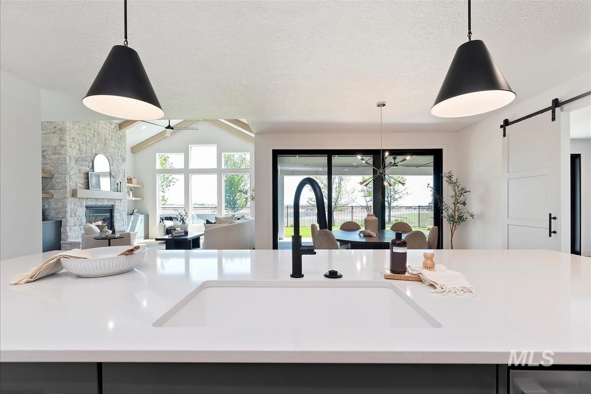 Kitchen featuring open floor plan, a barn door, light countertops, a textured ceiling, and a fireplace