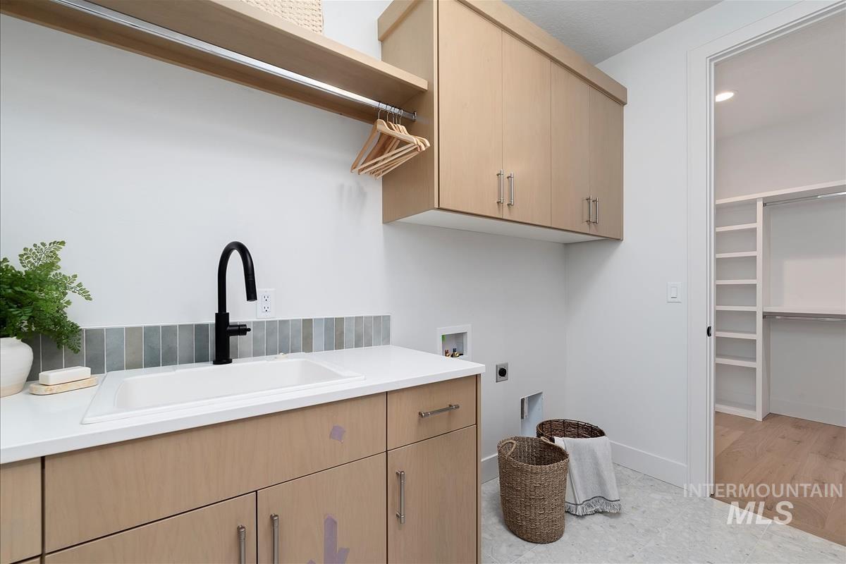 Washroom featuring hookup for an electric dryer, cabinet space, and hookup for a washing machine