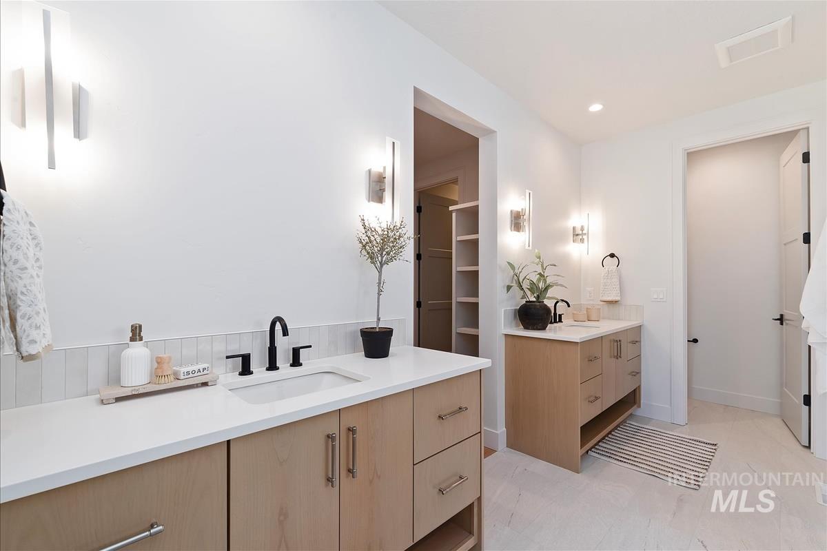 Full bath featuring two vanities