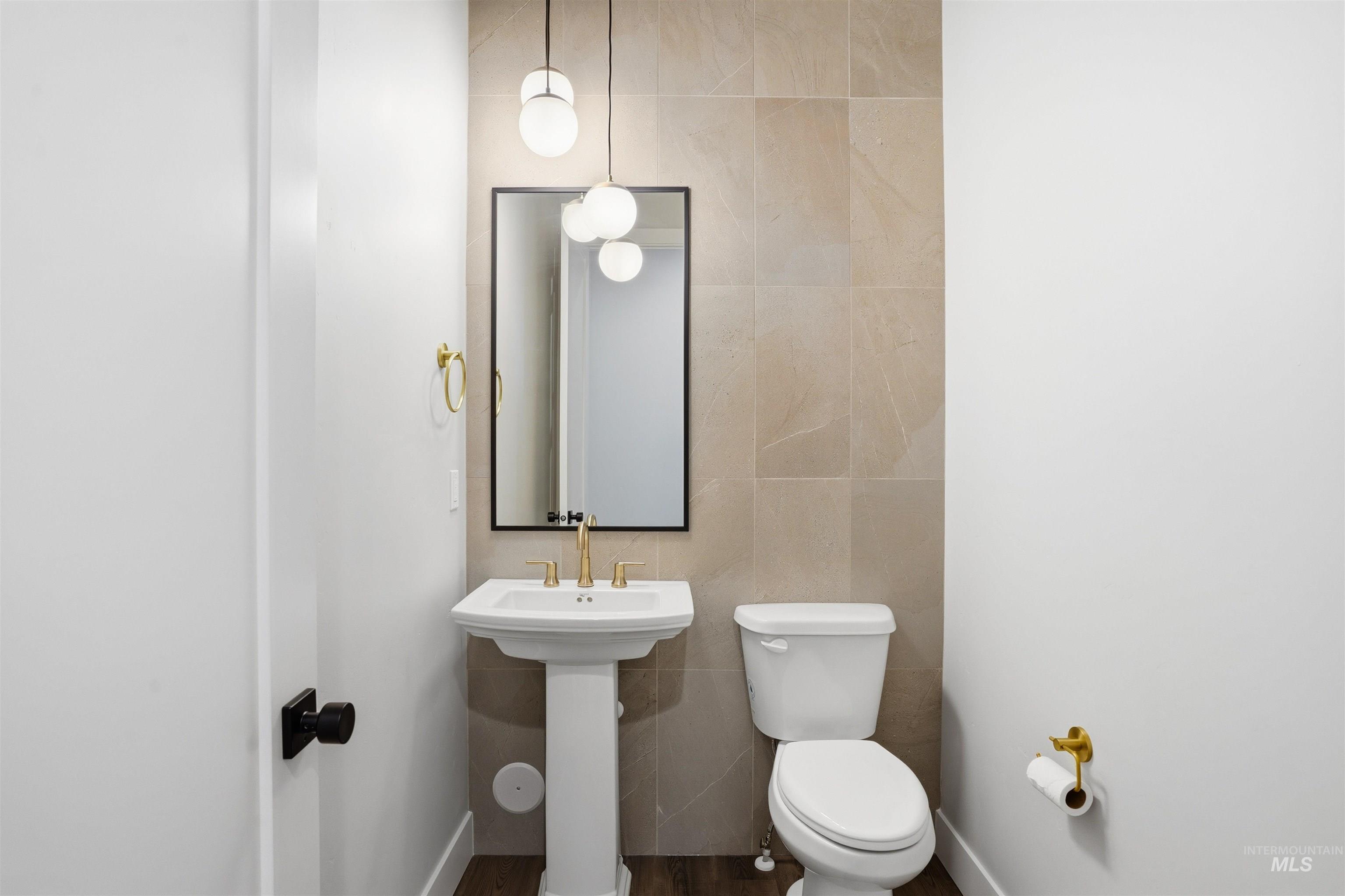 Bathroom featuring tile walls and toilet