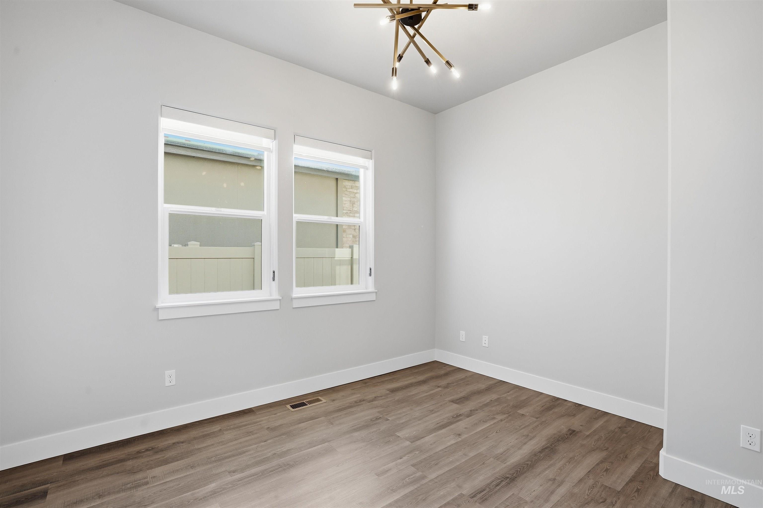 Spare room featuring wood finished floors and baseboards