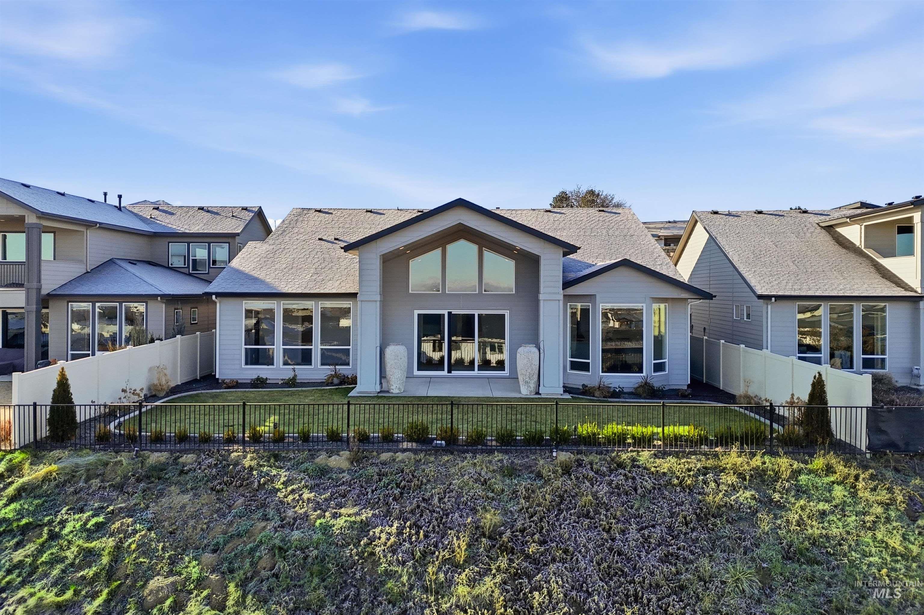 Back of property featuring a fenced backyard and a shingled roof