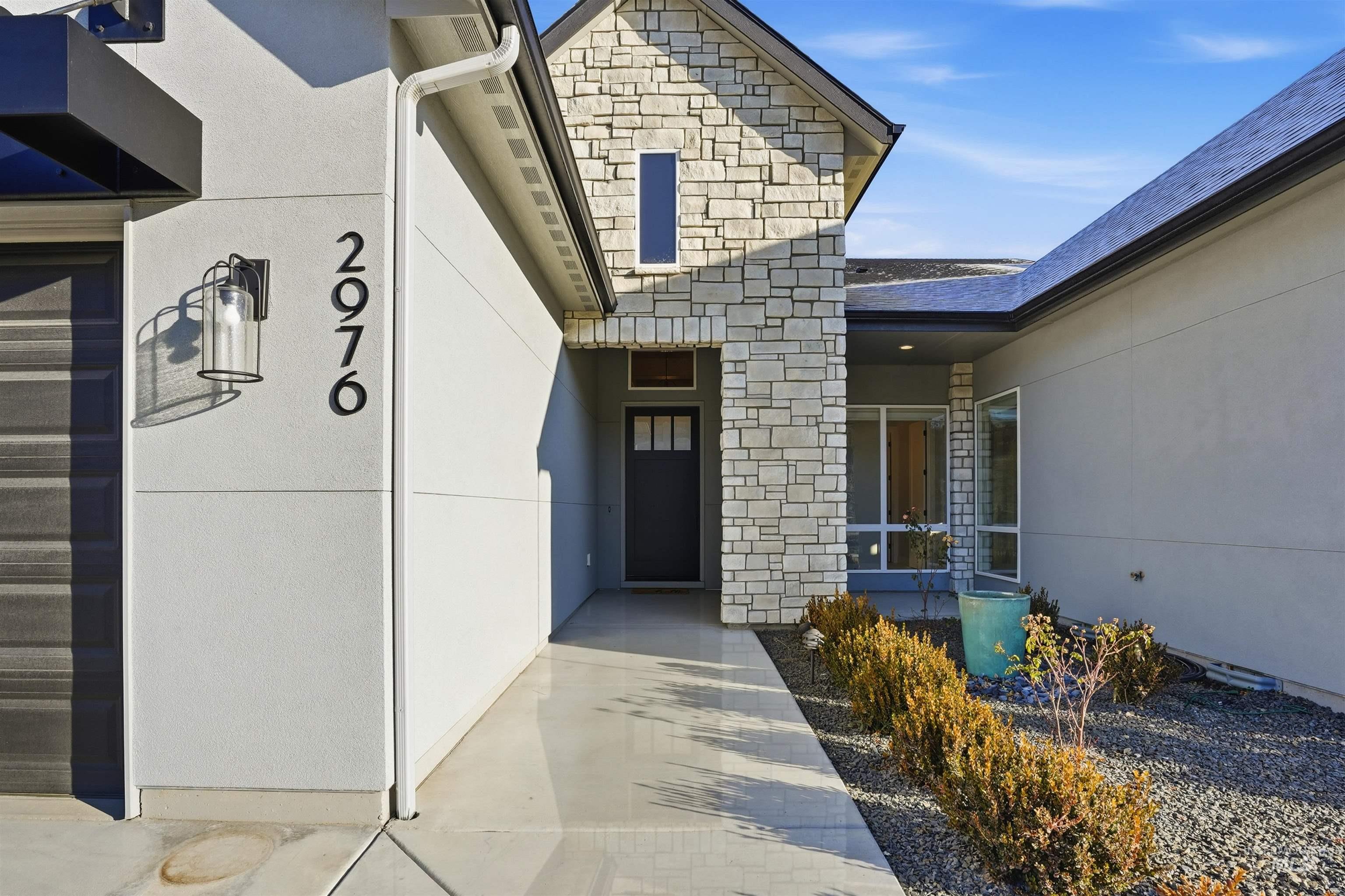 Property entrance featuring stone siding and stucco siding