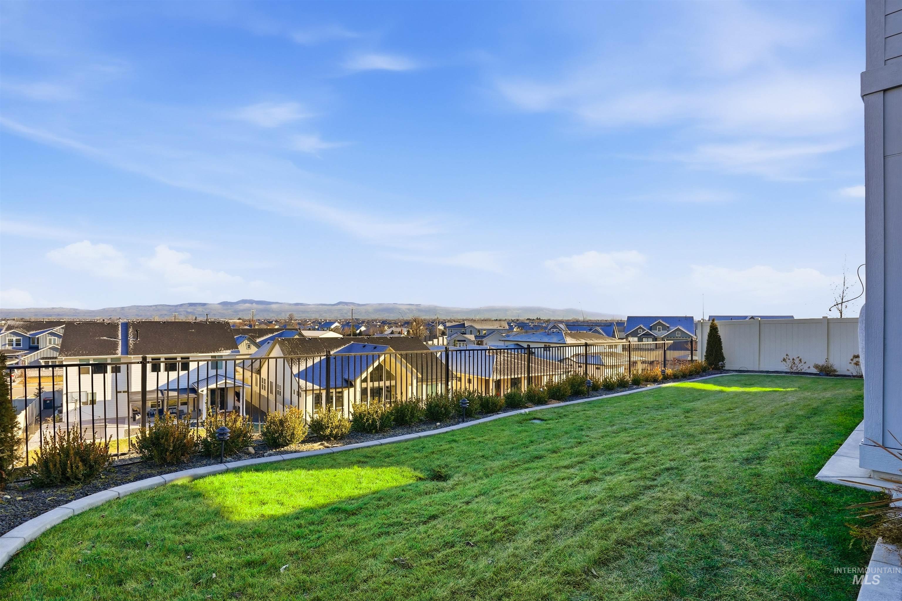 Fenced yard with a residential view and a mountain view