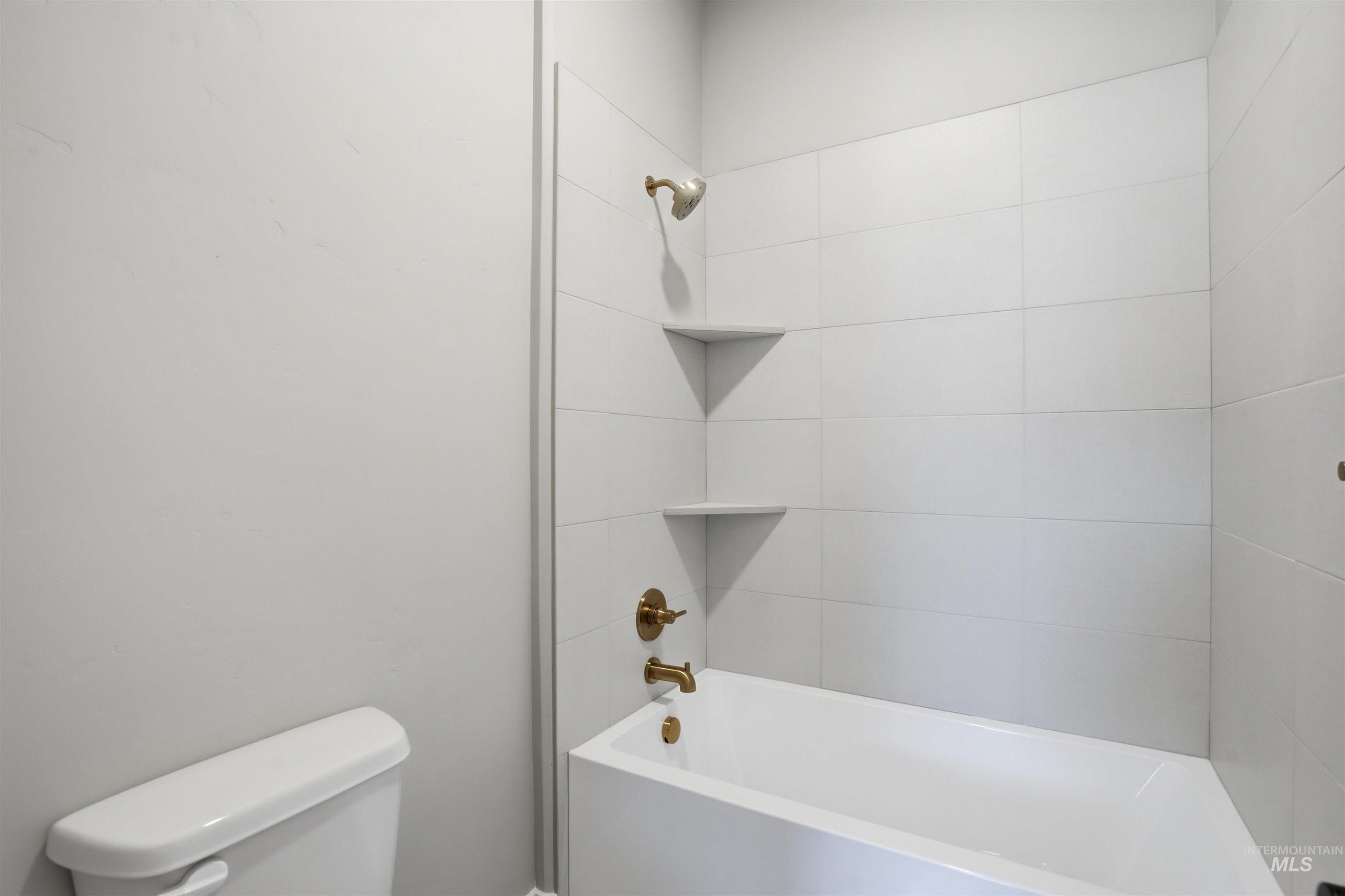 Full bathroom featuring shower / washtub combination and toilet