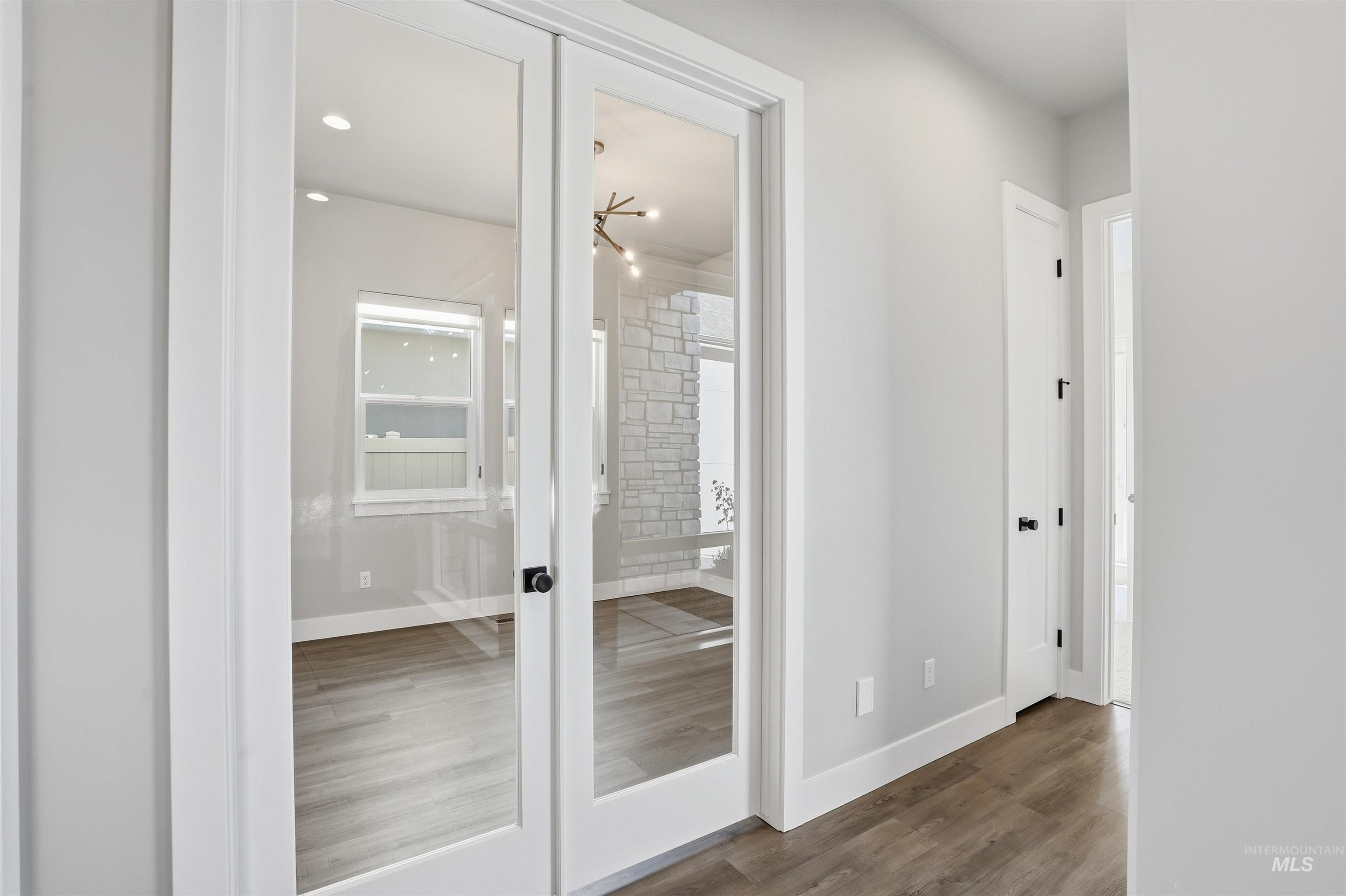 Corridor featuring french doors and dark wood-style floors