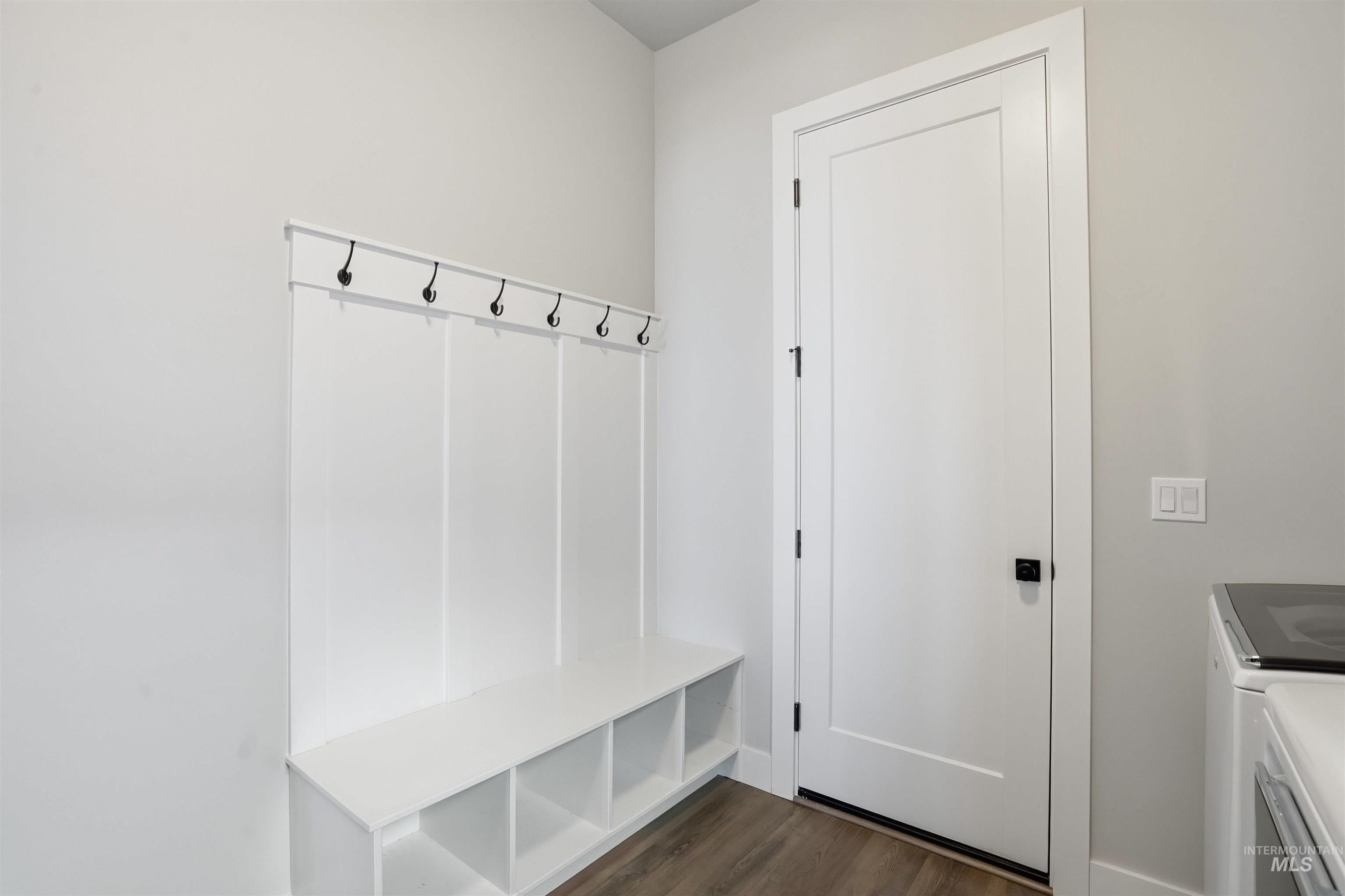 Mudroom with dark wood-type flooring and independent washer and dryer