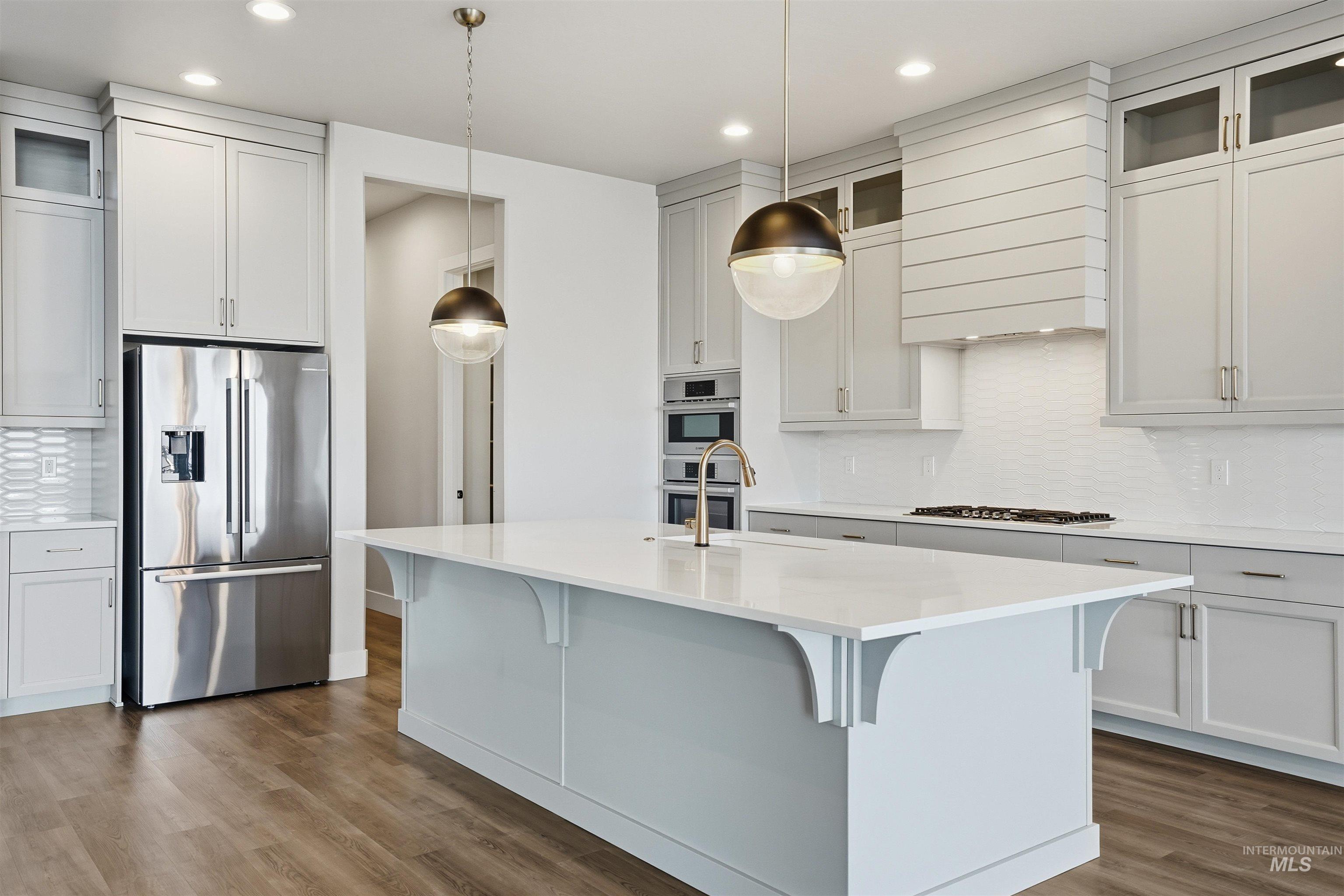 Kitchen with backsplash, glass insert cabinets, appliances with stainless steel finishes, dark wood finished floors, and recessed lighting