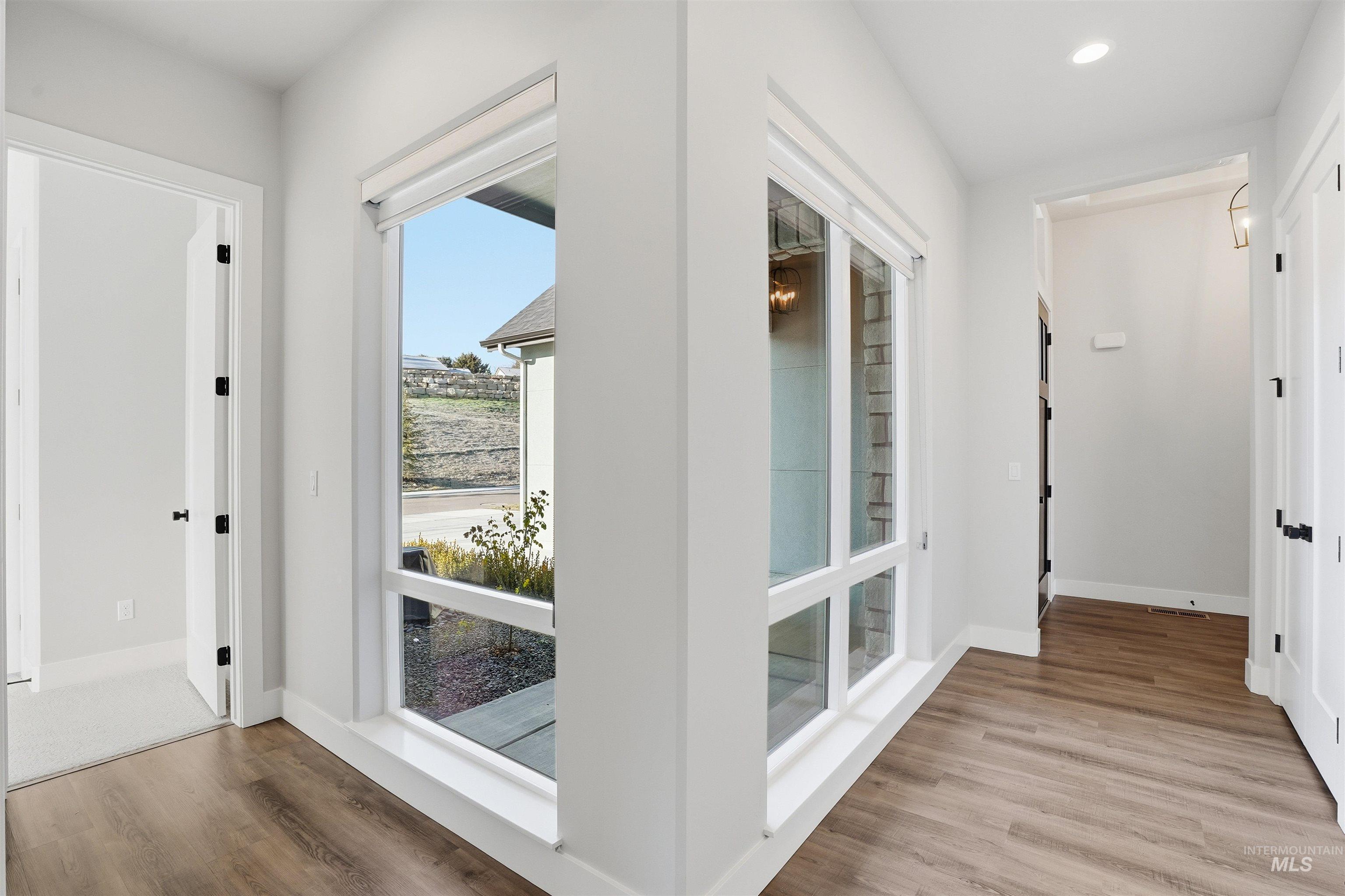 Entryway with wood finished floors and recessed lighting